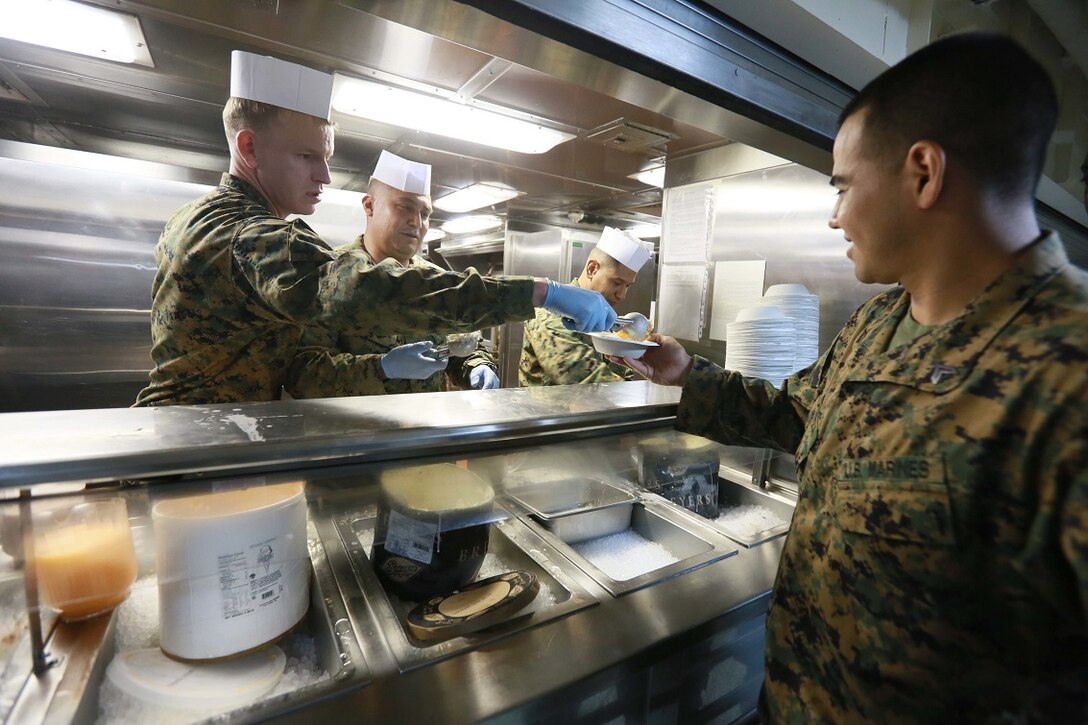 GULF OF ADEN (Aug. 7, 2015) U.S. Marine Gunnery Sgt. Karl Warnstedt, left, serves ice cream to Cpl. Oscar Sotomeza during an ice cream social aboard the amphibious transport dock ship USS Anchorage (LPD 23). Both Warnstedt and Sotomeza are members of Battalion Landing Team 3rd Battalion, 1st Marine Regiment, 15th Marine Expeditionary Unit.  The 15th MEU is embarked on the Essex Amphibious Ready Group and deployed to maintain regional security in the U.S. 5th Fleet area of operations.  (U.S. Marine Corps photo by Sgt. Steve H. Lopez/ Released)