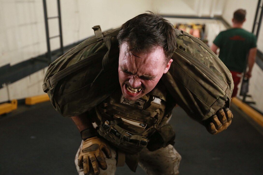 GULF OF ADEN (Aug. 10, 2015) U.S. Marine Lance Cpl. Joseph Bishop performs lunges carrying a 100- pound sandbag in the well deck of the amphibious transport dock ship USS Anchorage (LPD 23) during a squad competition. Bishop is a fire support coordination center 81mm mortar platoon representative with Weapons Company, Battalion Landing Team 3rd Battalion, 1st Marine Regiment, 15th Marine Expeditionary Unit. The 15th MEU is embarked on the Essex Amphibious Ready Group and deployed to maintain regional security in the U.S. 5th Fleet area of operations. (U.S. Marine Corps photo by Sgt. Steve H. Lopez/ Released)