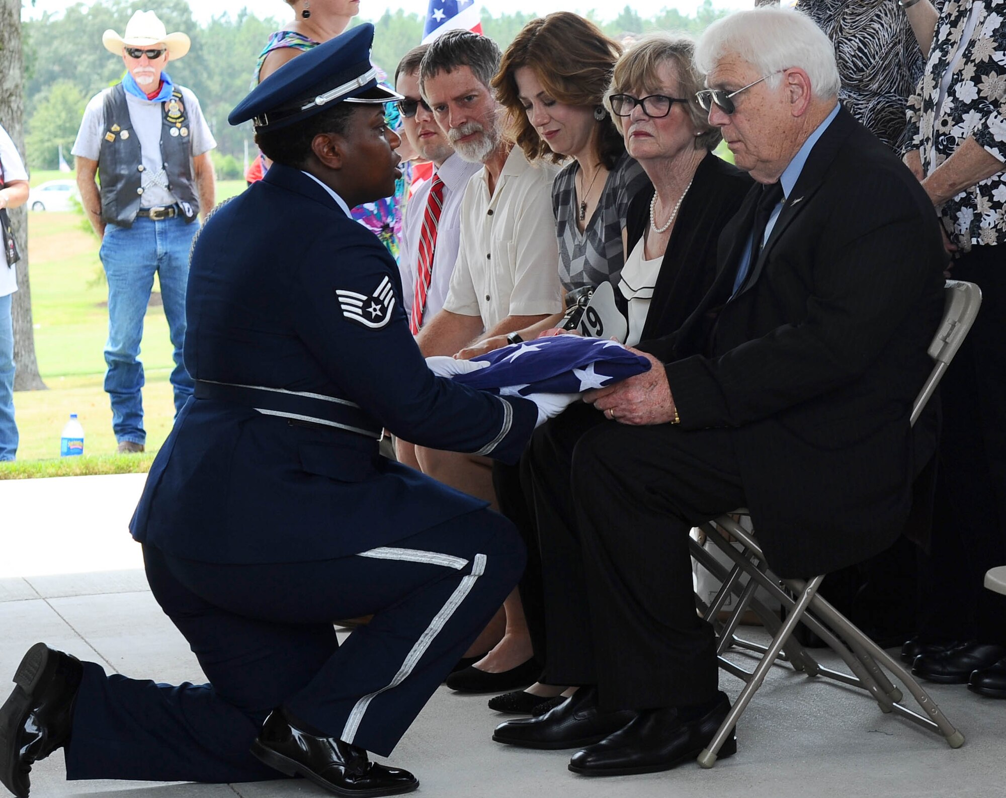Staff Sgt. Sherring Goodwin, a honor guardsman from Columbus Air Force Base, Mississippi, presents the folded American flag to Joe Partridge, the brother of the late Capt. Frederick Partridge, Aug. 10, 2015, at the Mississippi Veterans Memorial Cemetery. Full honors were presented for Frederick, to include a flag folding, firing party, color team and a bugle player who finished the ceremony with the playing of Taps. (U.S. Air Force photo/Senior Airman Kaleb Snay)