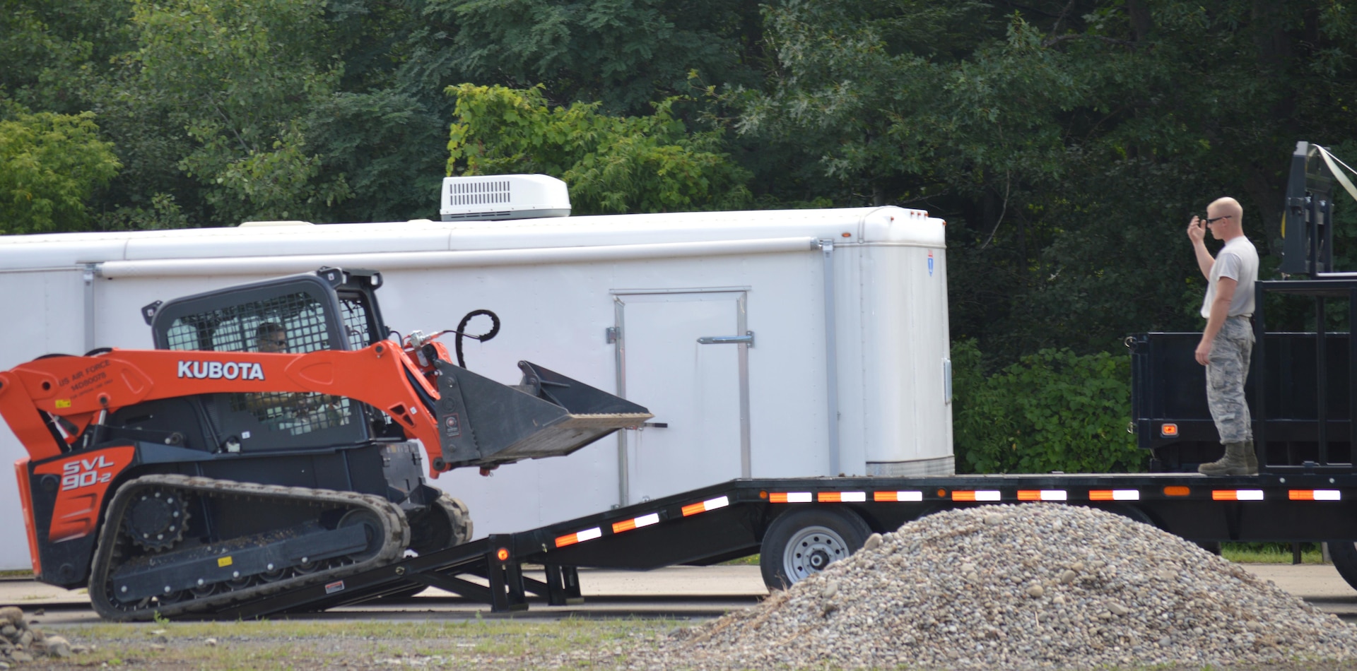 New York Air National Guard Tech. Sgt. Michael Eldred instructs a firefighter with the 109th Airlift Wing on how to operate a skid steer Aug. 12, 2015, at Stratton Air National Guard Base.