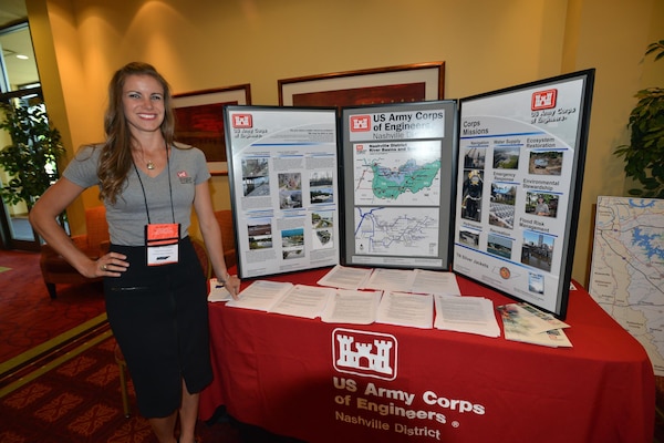 Lacey Thomason, planning project manager, Plans, Formulations Section Nashville District stands near the Corps of Engineers booth during the 6th Annual TN Association of Floodplain Managers Conference in Murfreesboro, Tenn. Aug. 11-14, 2015. 