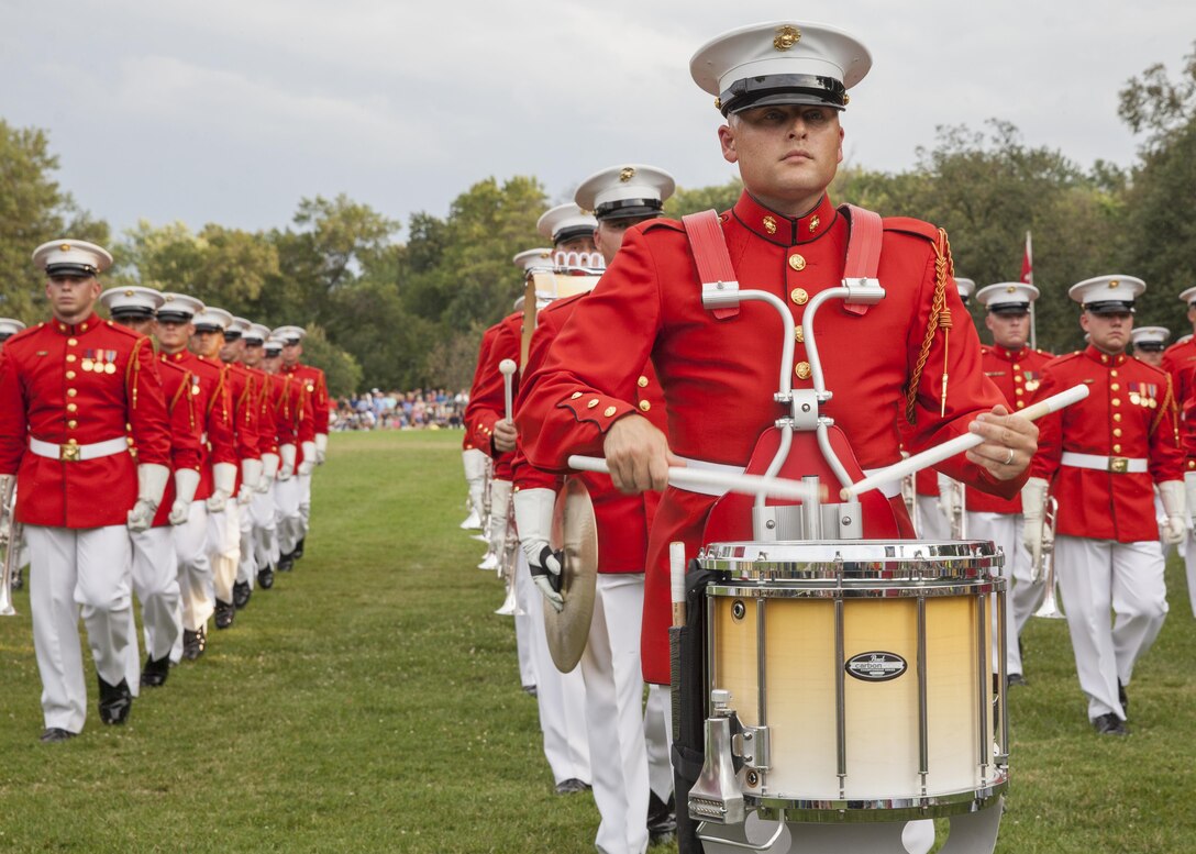U.S. Marines with the U.S. Marine Drum and Bugle Corps perform during a sunset parade at the Marine Corps War Memorial, Arlington, Va., Aug 11, 2015. Ms. Hollister K. Petraeus, CFPB assistant director, Service member Affairs, was the guest of honor for the parade, and Sgt. Maj. Ronald L. Green, 18th sergeant major of the Marine Corps, was the hosting official. Since September 1956, marching and musical units from Marine Barracks Washington, D.C., have been paying tribute to those whose “Uncommon Valor was a common virtue” by presenting sunset parades in the shadow of the 32-foot high figures of the United States Marine Corps War Memorial. 