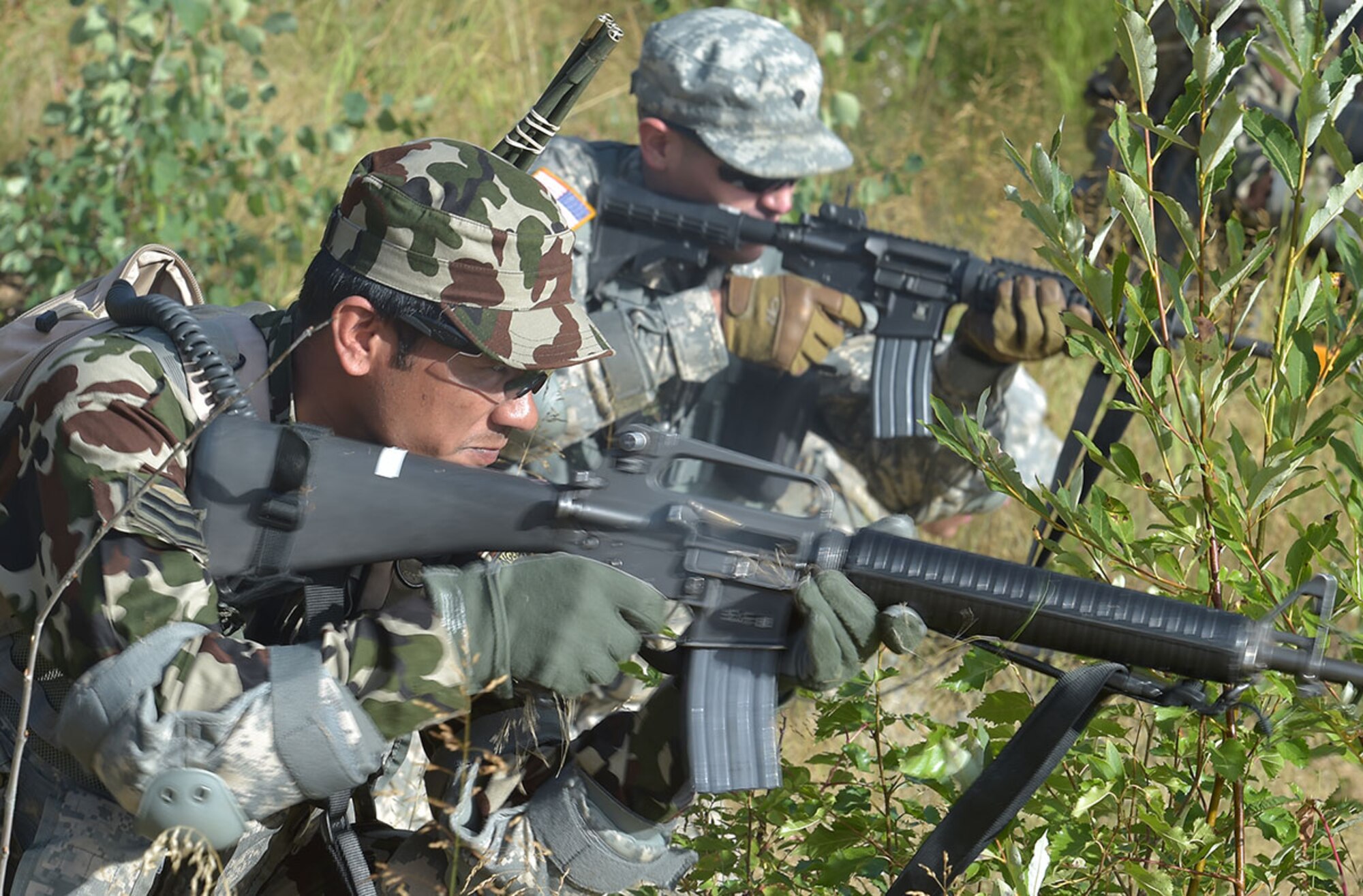 A Nepalese soldier fights alongside a U.S. Army Alaska specialist during an exercise during the Warrior Leader Course Aug. 12. The WLC, hosted at the Sergeant First Class Christopher R. Brevard Noncommissioned Officer Academy on JBER, is a month-long, hard-hitting and intensive course that teaches the basic skills to lead small groups of Soldiers and advance to the rank of sergeant. The student exchange is an ongoing part of USARAK’s collaboration with Nepal as part of the Regional Partnership Program, which is designed to enhance interoperability for a variety mission sets across the Pacific theater. (U.S. Air Force photo/Justin Connaher)