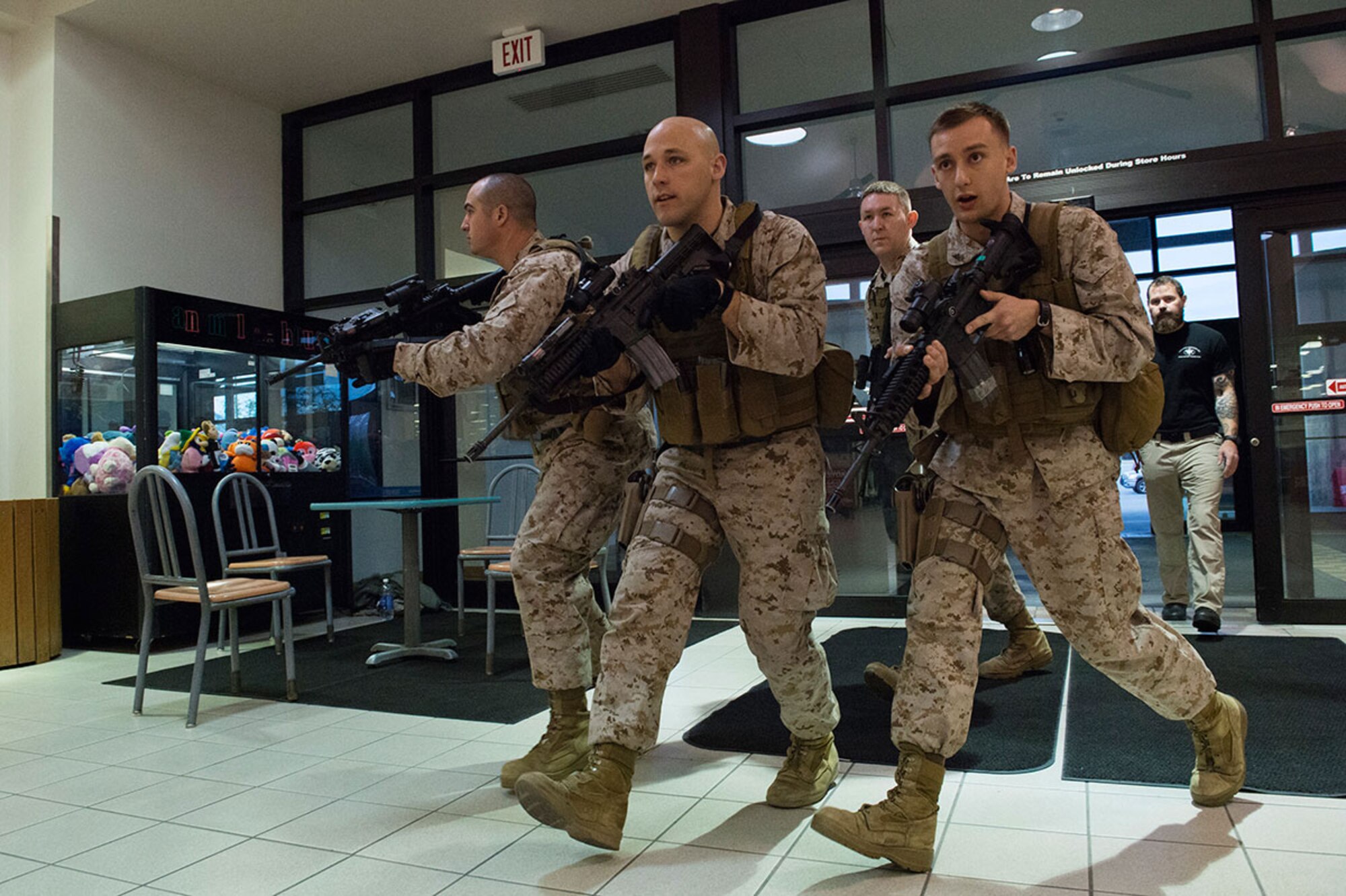 Marines assigned to Delta Company, 4th Law Enforcement Battalion, search for an active shooter threat while conducting high-risk response training at the Exchange on Joint Base Elmendorf-Richardson May 15. Pacific Air Forces High-Risk Response Training is a project that provides security forces personnel with an intensive course based in real-life scenarios emphasizing effective tactics to eliminate active shooters and other threats. (U.S. Air Force photo/Alejandro Pena)