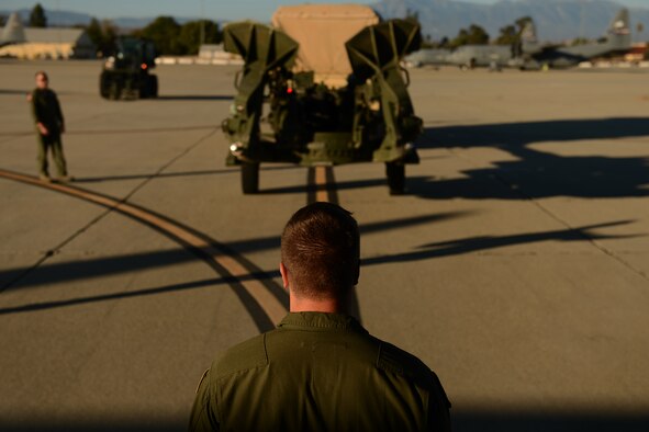 Senior Airman Ryan Ludwig, 8th Airlift Squadron loadmaster, guides an Army High-Mobility Rocket System on to a C-17 Aug. 4, 2015, on March Air Reserve Base, Calif., for a Joint Operation Access Exercise. The HIMARS once unloaded from the C-17, can lock on to a target with GPS coordinates. (U.S. Air Force photo\ Staff Sgt. Tim Chacon)
