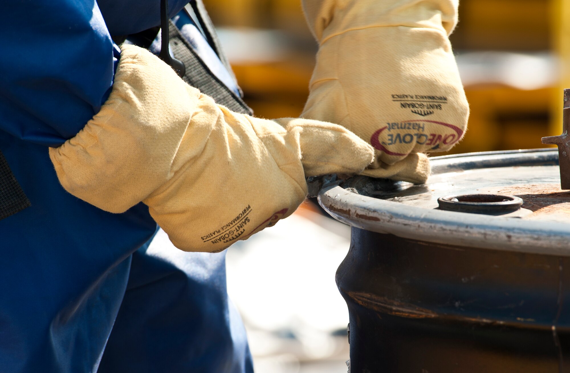 Senior Airman Nicholas Bouselli, 92nd Civil Engineer Squadron emergency management journeyman, opens the lid of a metal drum containing the clothes of those directly exposed by the chemicals Aug. 12, 2015, at Pacific Steal and Recycling in Spokane, Wash. Fairchild emergency management Airmen employed a variety of their skills to handle the decontamination operations during a leak of chlorine gas that resulted in the hospitalization of at least four people, two of whom were in critical condition, and at least 17 others who were downwind of the plume. (U.S. Air Force photo/Airman Sean Campbell)