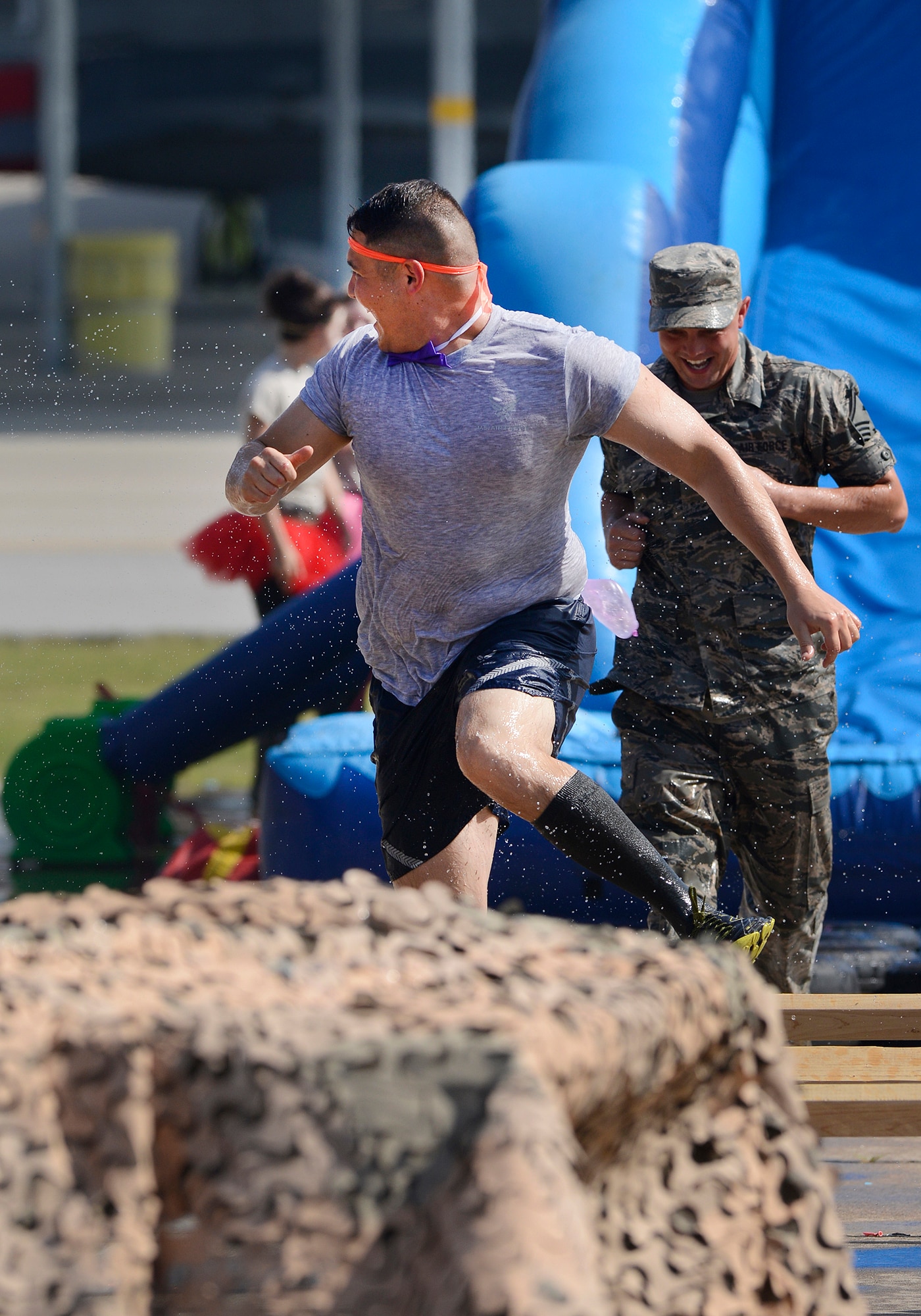 Staff Sgt. Alan Williams, 138th Fighter Wing Chaplains Assistant, runs from people trying to soak him on the obstacle course during the 138th Fighter Wing's combat dining-in held Aug. 1, 2015 at the Tulsa Air National Guard base.  The wing's senior non-commissioned officer's council sponsored the event as a way to enhance camaraderie and promote esprit de corps throughout the ranks.   (U.S. National Guard photo by Master Sgt. Mark A. Moore/Released)