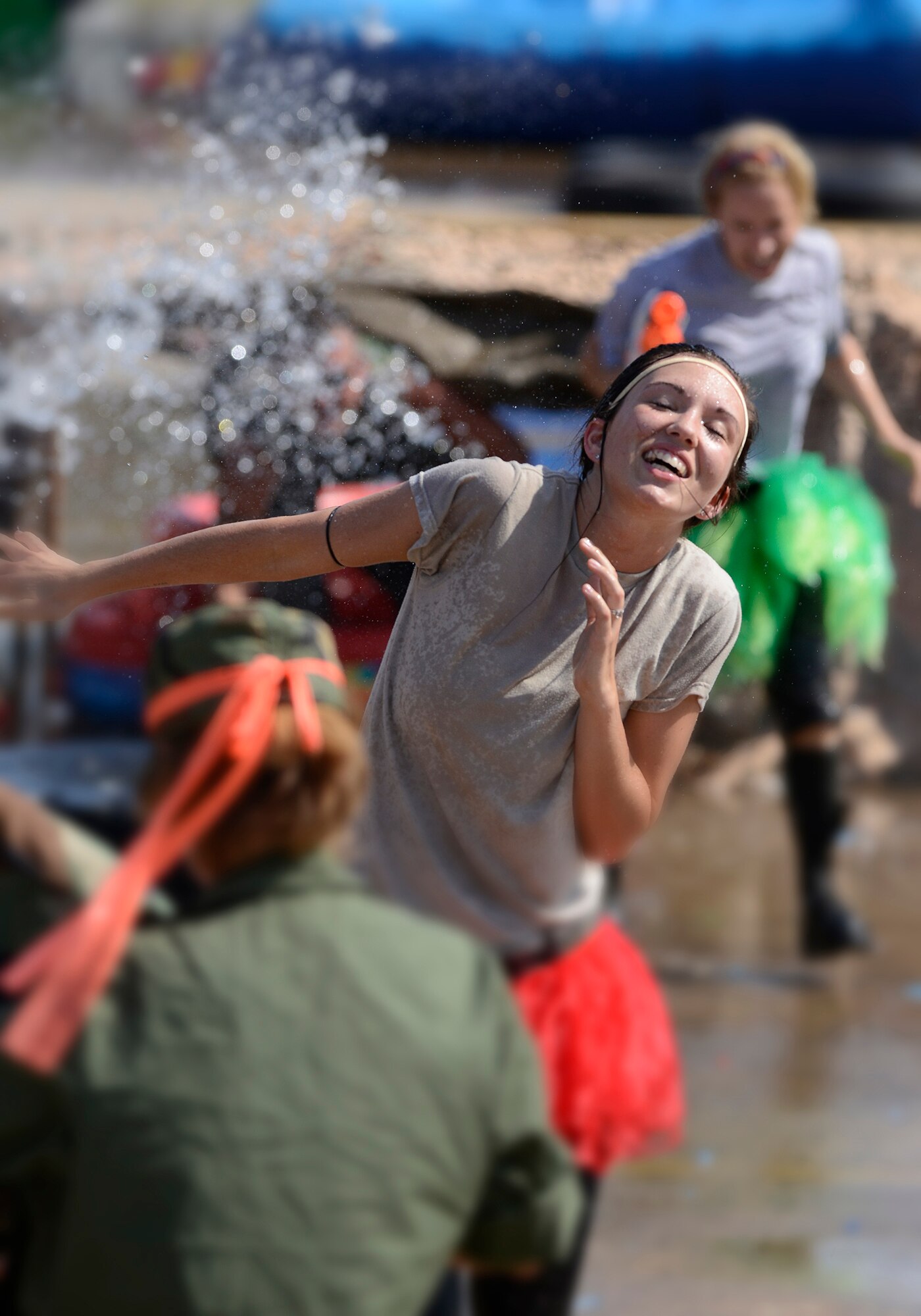 Airman 1st Class Natasha Applegate, 138th Force Support Squadron, cringes from water being thrown on her while running the obstacle course during the 138th Fighter Wing's combat dining-in held Aug. 1, 2015 at the Tulsa Air National Guard base.  The wing's senior non-commissioned officer's council sponsored the event as a way to enhance camaraderie and promote esprit de corps throughout the ranks.   (U.S. National Guard photo by Master Sgt. Mark A. Moore/Released)