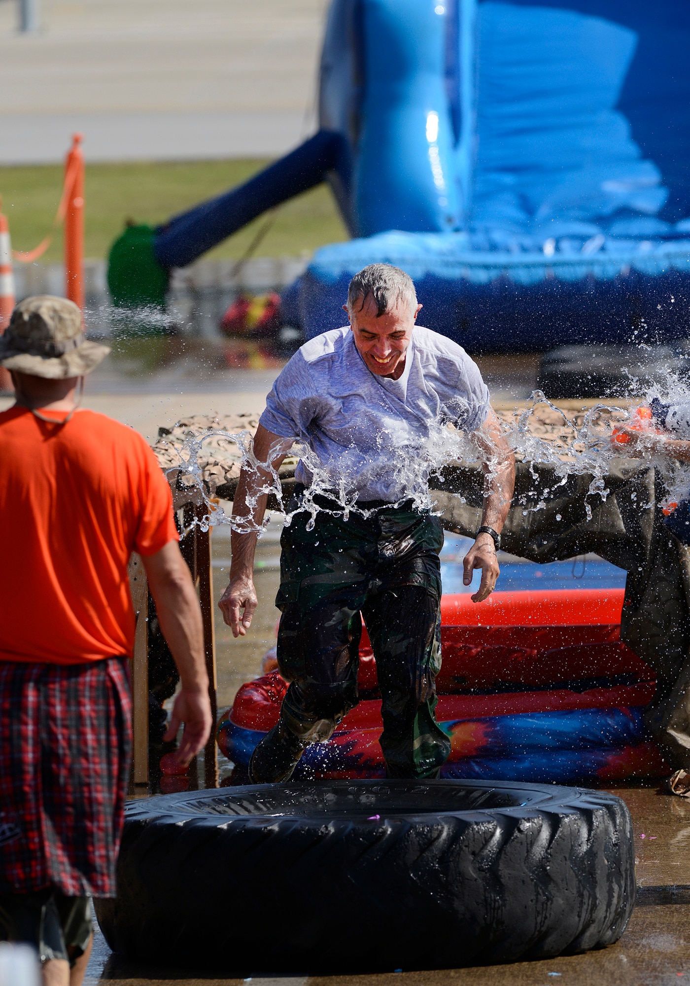 Chief Master Sgt. Paul Hammond, 138th Force Support Squadron, is doused with water while running the obstacle course during the 138th Fighter Wing's combat dining-in held Aug. 1, 2015 at the Tulsa Air National Guard base.  The wing's senior non-commissioned officer's council sponsored the event as a way to enhance camaraderie and promote esprit de corps throughout the ranks.   (U.S. National Guard photo by Master Sgt. Mark A. Moore/Released)
