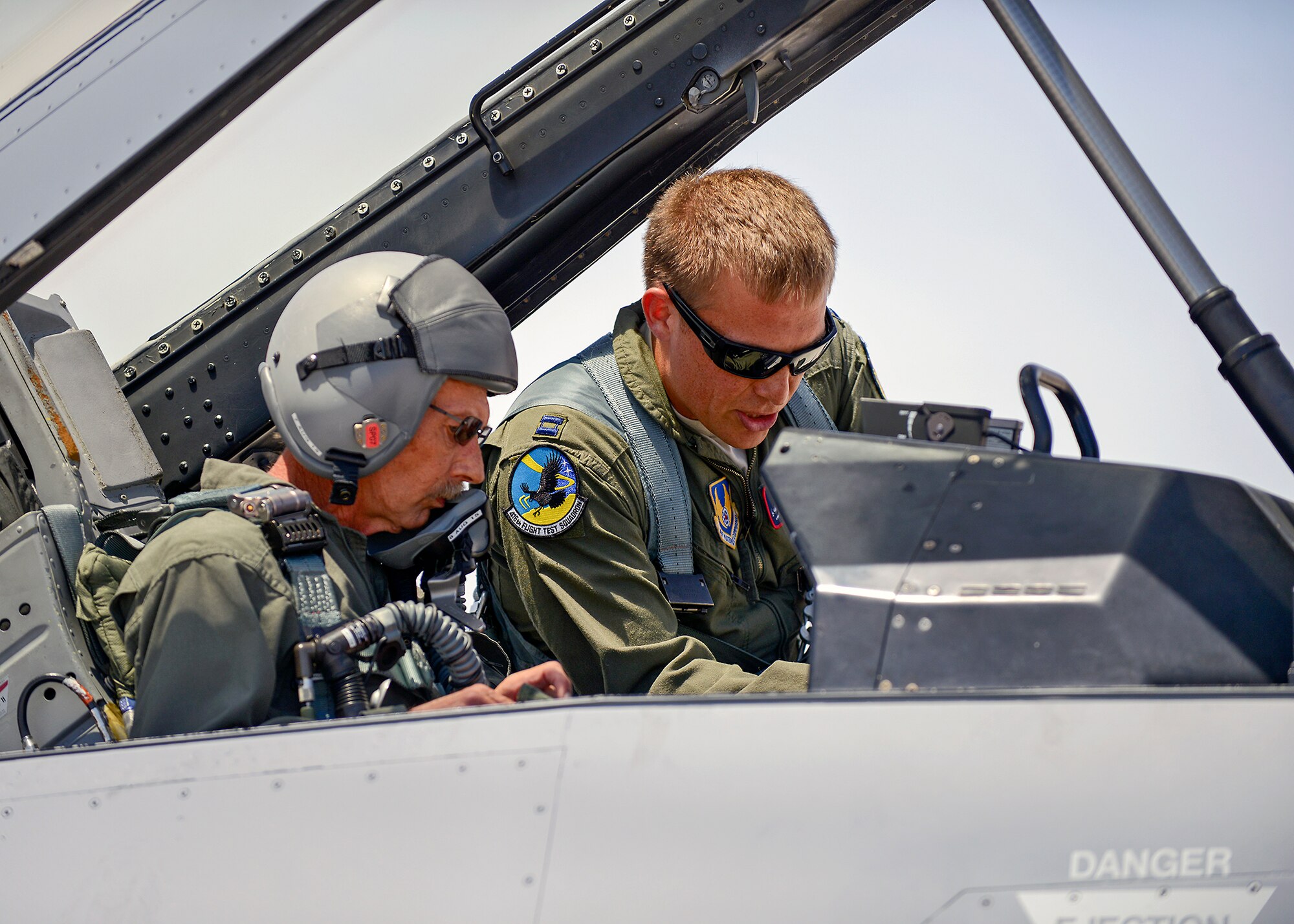Capt. Joe Schenkel (right), 416th Flight Test Squadron F-16 test pilot, goes over the cockpit layout with Greg Welsh, a 33-year veteran maintainer and maintenance manager with the 412th Aircraft Maintenance Squadron, before taking part in an actual flight test mission Aug. 4, as part of the 412th Operations and Maintenance Immersion Program. This program is part of an initiative to give operators and maintainers the opportunity to create positive interaction so both gain insight into each other’s work dynamic. (U.S. Air Force photo by Jet Fabara)