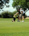 Carl and Carla Younce consult prior to putting at the Grand Forks Country Club for the semiannual Military Affairs Committee golf tournament Aug. 10, 2015, in Grand Forks, North Dakota. Grand Forks Air Force Base hosted another MAC tournament earlier this year. (U.S. Air Force photo by Senior Airman Desiree Economides/Released) 