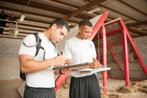 Capt. Carlos Mateo, left, Officer Training School deputy chief of training, and Capt. Kris Walker, OTS chief of training, evaluate Montgomery Police Department officers as they complete a task in the Leadership Reaction Course Aug. 7, 2015. The police officers were participating in a new leadership consortium exchange with OTS faculty to learn and apply leadership concepts both in the classroom and field environments. (U.S. Air Force photo by Tech. Sgt. Sarah Lociano/Released)