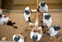 Capt. Kris Walker, chief of training at Officer Training School, evaluates members of the Montgomery Police Department as they attempt an obstacle challenge at the Leadership Reaction Course at Maxwell Air Force Base, Ala., Aug. 7, 2015. The police officers were participating in a new leadership consortium exchange with OTS faculty to learn and apply leadership concepts both in the classroom and field environments. (U.S. Air Force photo by Tech. Sgt. Sarah Lociano/Released)
