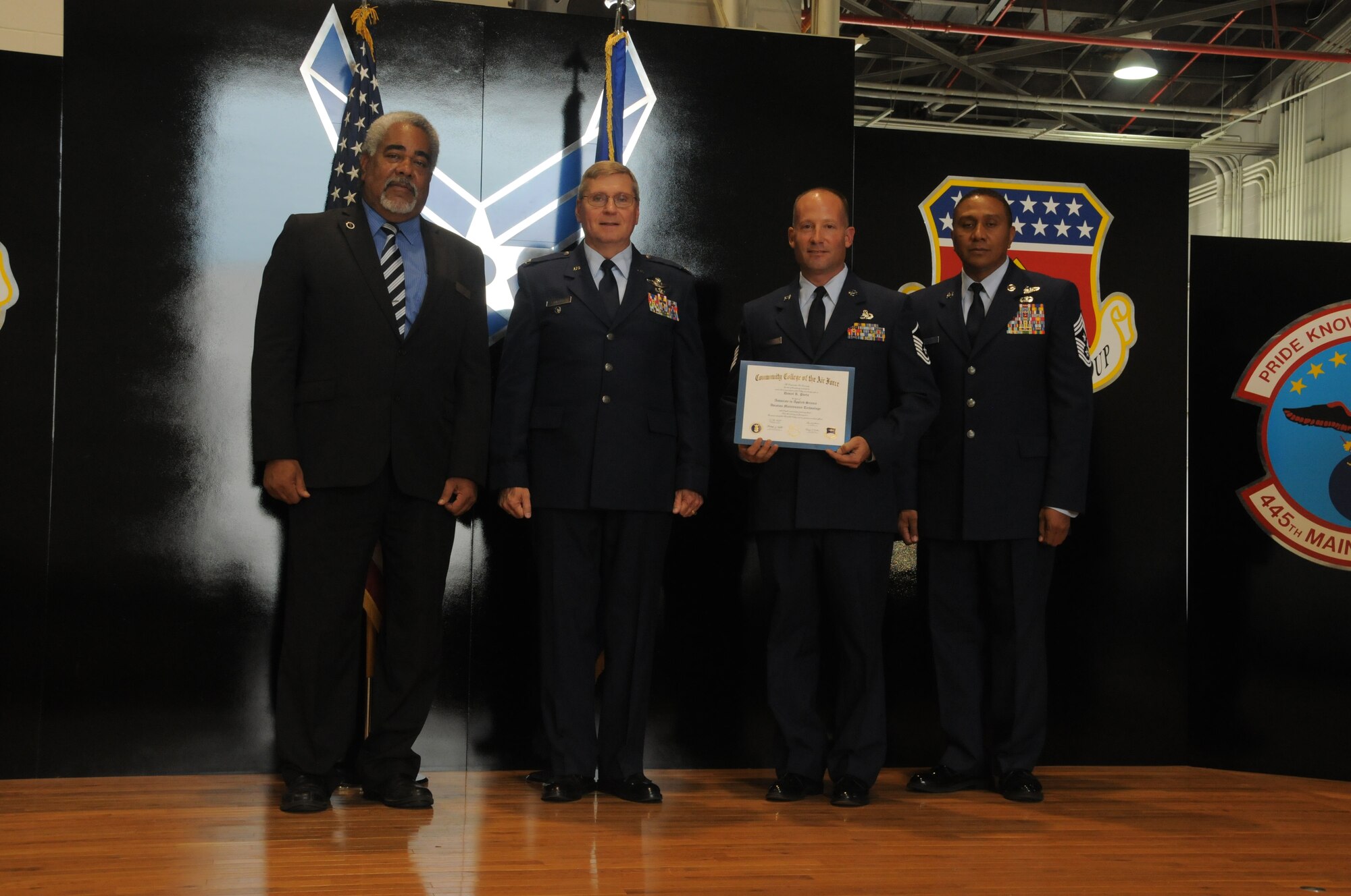 WRIGHT-PATTERSON AIR FORCE BASE, Ohio - Master Sgt. Daniel Porta, 445th Maintenance Group chief of quality assurance, receives his Community College of the Air Force degree in aviation maintenance technology during the July 12, 2015 CCAF graduation ceremony. Porta was one of 36 graduates to receive their CCAF degree that day. Mayor Brian Jarvis, City of Beavercreek, spoke to the graduates and their families and presented the certificates. (U.S. Air Force photo/Tech. Sgt. Anthony Springer)