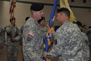 Col. John L. Smith, 128th Aviation Brigade commander, passes the 2nd Battalion, 210th Aviation Regiment guidon to U.S. Army Lt. Col. Thomas W. Bamford during the 2-210th Avn. Reg. change of command ceremony at Fort Eustis, Va., Aug. 7, 2015. Bamford started his career as an enlisted artillery cannon crewman before becoming a warrant officer and then commissioned officer. (U.S. Army photo by Rodney Speed/Released)