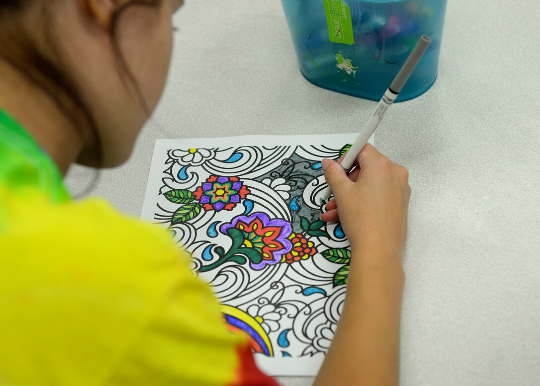 A Langley Youth Center volunteer colors at Langley Air Force Base, Va., July 24, 2015. Volunteer staff members remain actively involved with the children that attend the center, in a broad range of activities including coloring, board games and sports. (U.S. Air Force photo by Airman 1st Class Derek Seifert/Released)