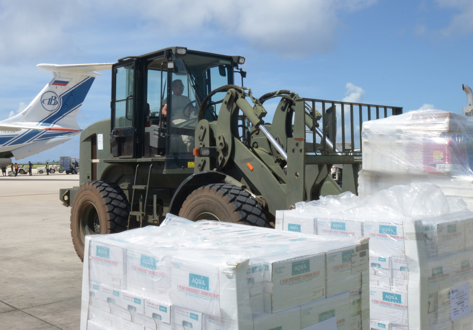 Senior Airman Louie Lascina, a native of Saipan, stages cases of water to be distributed to island residents as part of Typhoon Soudelor relief efforts. Airmen from the 36th Contingency Response Group deployed from Andersen Air Force Base to help the Federal Emergency Management Agency and Red Cross with transporting supplies through Saipan International Airport. (U.S. Navy photo by Mass Communication Specialist 3rd Class Kristina D. Marshall/Released)