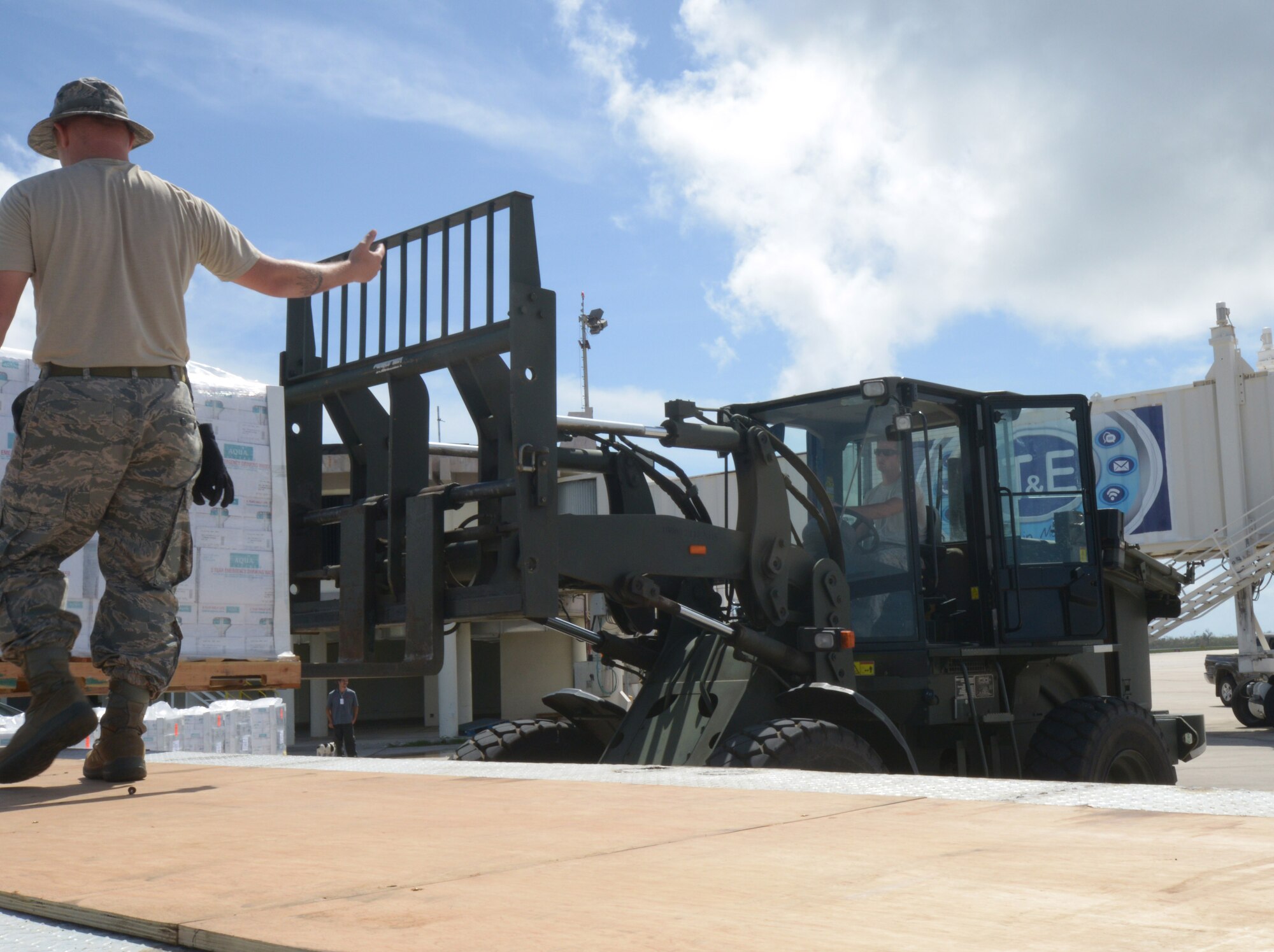 Master Sgt. Michael Sibley directs Staff Sgt. Josh Foley as he loads cases of water onto a truck to be distributed to residents of Saipan. Airmen from the 36th Contingency Response Group deployed from Andersen Air Force Base to help the Federal Emergency Management Agency and Red Cross with transporting supplies as part of Typhoon Soudelor relief efforts. (U.S. Navy photo by Mass Communication Specialist 3rd Class Kristina D. Marshall/Released)