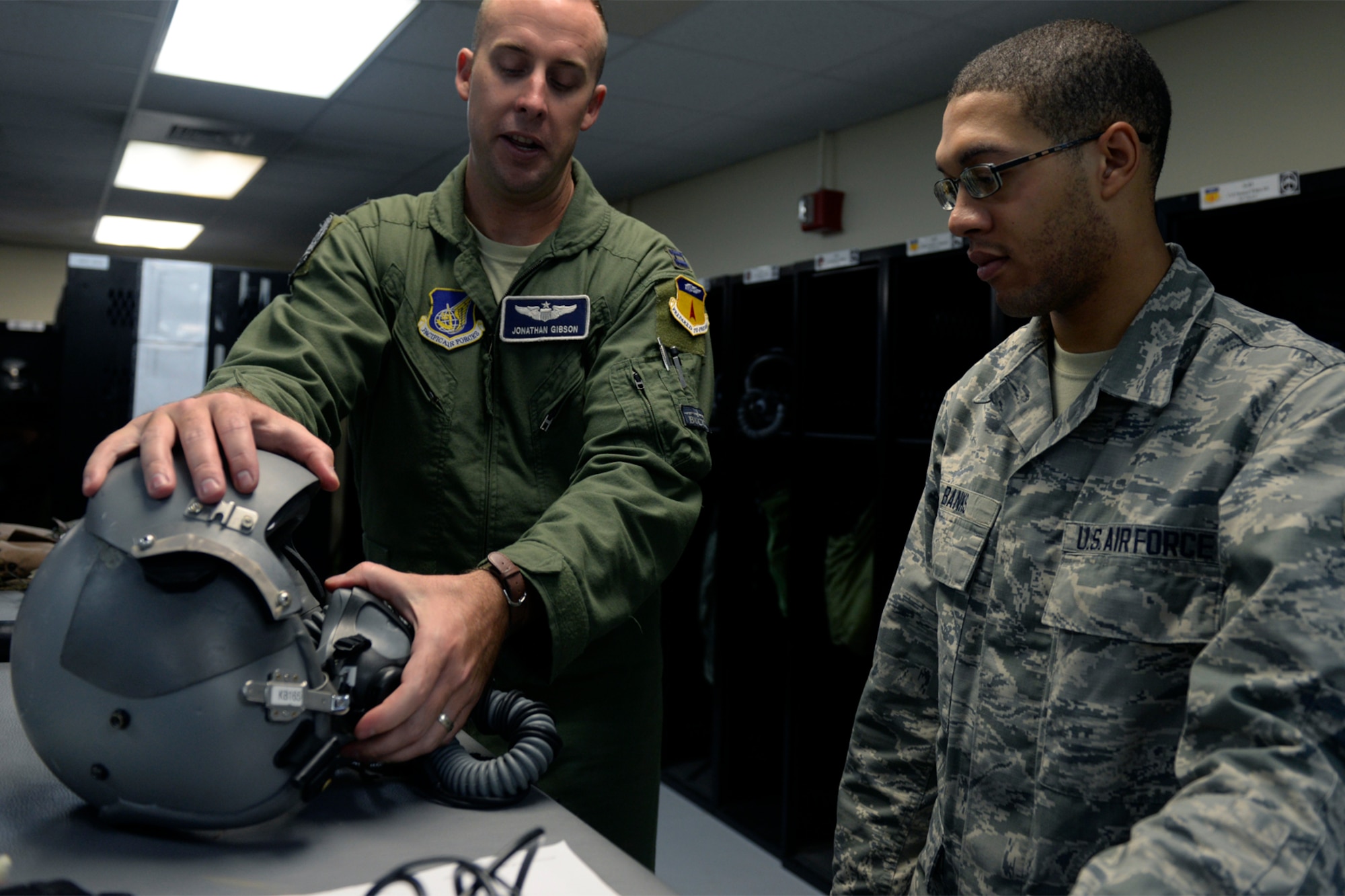 Capt. Jonathan Gibson, 20th Expeditionary Bomb Squadron B-52 Stratofortress pilot, left, informs Airman 1st Class Michael Banks, 20th EBS aircrew flight equipment specialist, about needed adjustments to his flight helmet Aug. 12, 2015, at Andersen Air Force Base, Guam. As an AEF specialist Banks repairs and maintains vital life support equipment for aviators.  (U.S. Air Force photo by Staff Sgt. Alexander W. Riedel/Released)