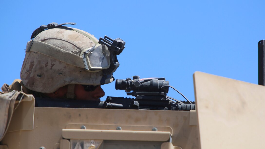 Cpl. Derek King, a landing support specialist with Combat Logistics Battalion 1, Combat Logistics Regiment 1, 1st Marine Logistics Group, takes aim with his M16 service rifle from the turret of a Mine Resistant Ambush Protected All Terrain Vehicle during a mounted patrol exercise at Marine Corps Air Ground Combat Center Twentynine Palms, California, Aug. 10, 2015. Marines and sailors with the unit conducted a mounted patrol exercise prior to Large Scale Exercise 15, a combined U.S. Marine Corps, Canadian and British exercise conducted at the brigade level and designed to enable live, virtual and constructive training for participating forces.