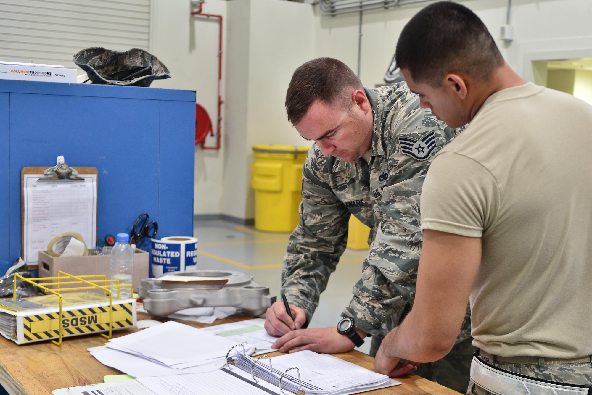 Airman 1st Class Berkeley Lopez, 379th Expeditionary Maintenance Squadron Nondestructive Inspection laboratory, helps a maintenance crew member sign in a brake part that will be tested for its stability August 12, 2015 at Al Udeid Air Base, Qatar. NDI Airmen inspect for cracks and flaws on aircraft and their components, aerospace ground equipment and safety equipment.  They also test jet engine oil samples, using a variety of methods, like magnetic particle, fluorescent penetrant, eddy current, radiography, optical and ultrasonic equipment. (U.S. Air Force photo/Staff Sgt. Alexandre Montes)   