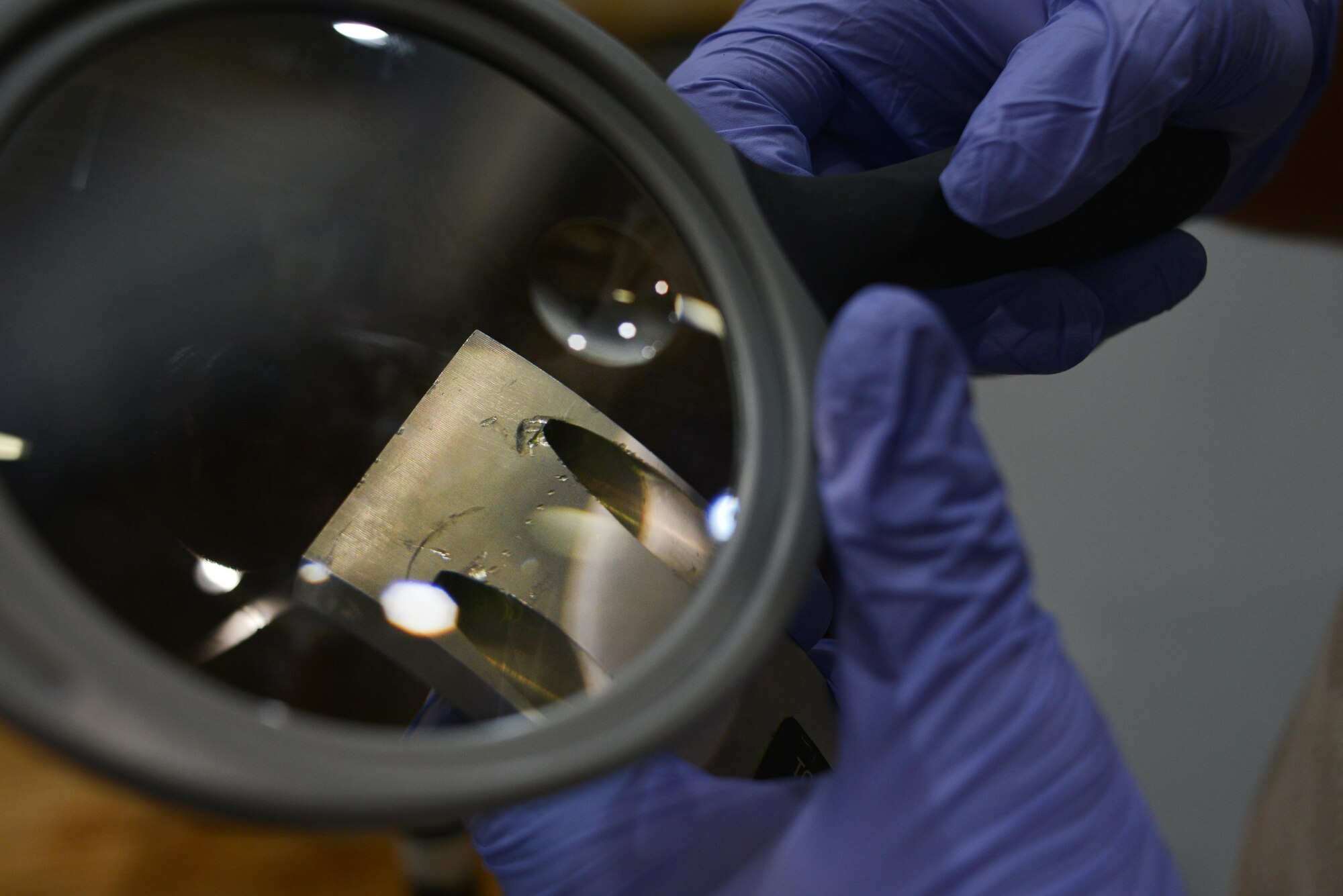 Airman 1st Class Berkeley Lopez, 379th Expeditionary Maintenance Squadron Nondestructive Inspection laboratory, inspects an F-16 Fighting Falcon brake caliper for fractures August 12, 2015 at Al Udeid Air Base, Qatar. NDI Airmen inspect for cracks and flaws on aircraft and their components, aerospace ground equipment and safety equipment.  They also test jet engine oil samples, using a variety of methods, like magnetic particle, fluorescent penetrant, eddy current, radiography, optical and ultrasonic equipment. (U.S. Air Force photo/Staff Sgt. Alexandre Montes)   