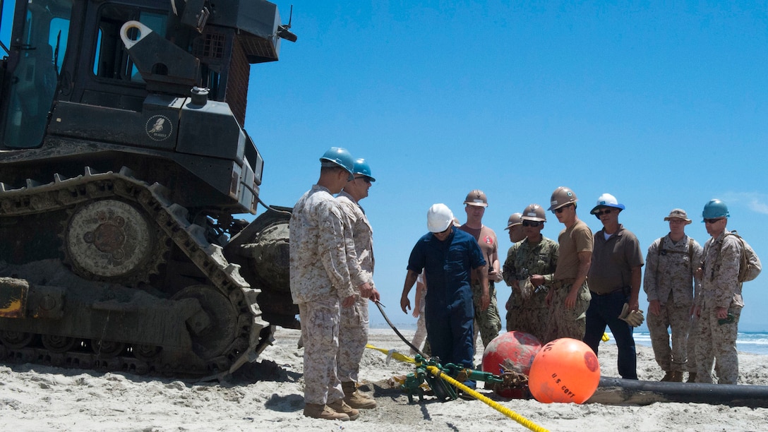 Marines with Bulk Fuel Co., 1st Marine Logistics Group, team up with Sailors from Amphibious Construction Battalion 1 to perform a beach unloading exercise using the Beach Termination Unit, in Coronado, California, Aug. 1-4, 2015.  Approximately 30 Marines with Bulk Fuel Company, 7th Engineer Support Battalion, 1st Marine Logistics Group, teamed up with Sailors from Amphibious Construction Battalion 1 to conduct a beach unloading exercise. What made the training unique was the use of the BTU, which allows Marines to transfer fuel from a ship out in the ocean to Marines on land.