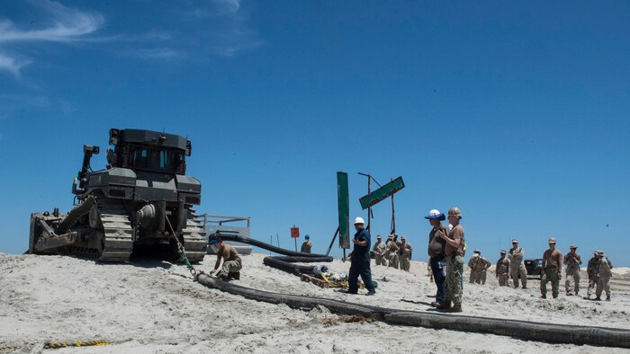 Marines with Bulk Fuel Company, 1st Marine Logistics Group, team up with sailors from Amphibious Construction Battalion 1 to perform a beach unloading exercise using the Beach Termination Unit, in Coronado, California, Aug. 1-4, 2015. Approximately 30 Marines with Bulk Fuel Company, 7th Engineer Support Battalion, 1st Marine Logistics Group, teamed up with sailors from Amphibious Construction Battalion 1 to conduct a beach unloading exercise. What made the training unique was the use of the BTU, which allows Marines to transfer fuel from a ship out in the ocean to Marines on land.