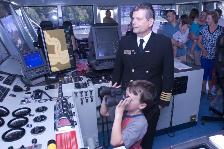 Motor Vessel Mississippi Captain Lee Hendrix watches as Garrett Durrett, 5, of Pelham, Ala., looks through a pair of binoculars during a public tour of the vessel docked at Ross's Landing in Chattanooga, Tenn., Aug. 7, 2015. The M/V Mississippi spends more than 90 percent of its time as a working towboat, moving barges, equipment and supplies on the lower Mississippi River.  The M/V Mississippi, built in 1993 by Halter Marine, is the fifth Army Corps of Engineers towboat to bear the name.  It is the largest diesel towboat in the United States at 241-feet long, 58-feet wide and five stories high.  Three 2,100-horsepower diesel engines power the vessel.