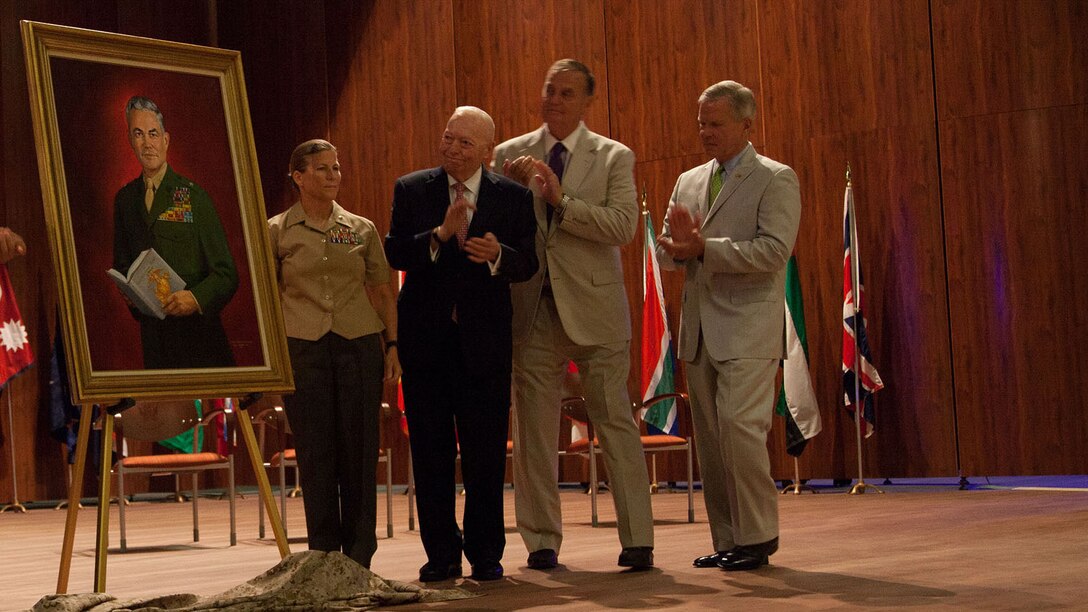 The official party at the dedication ceremony of the John W. Warner Center for Advanced Military Studies and the Brigadier General Edwin H. Simmons Center for Marine Corps History unveil a portrait of Simmons at Marine Corps Base Quantico, Virginia, Aug. 7, 2015. The ceremony honored both Simmons and John W. Warner, both of whom played an integral role in improving military education during their careers.