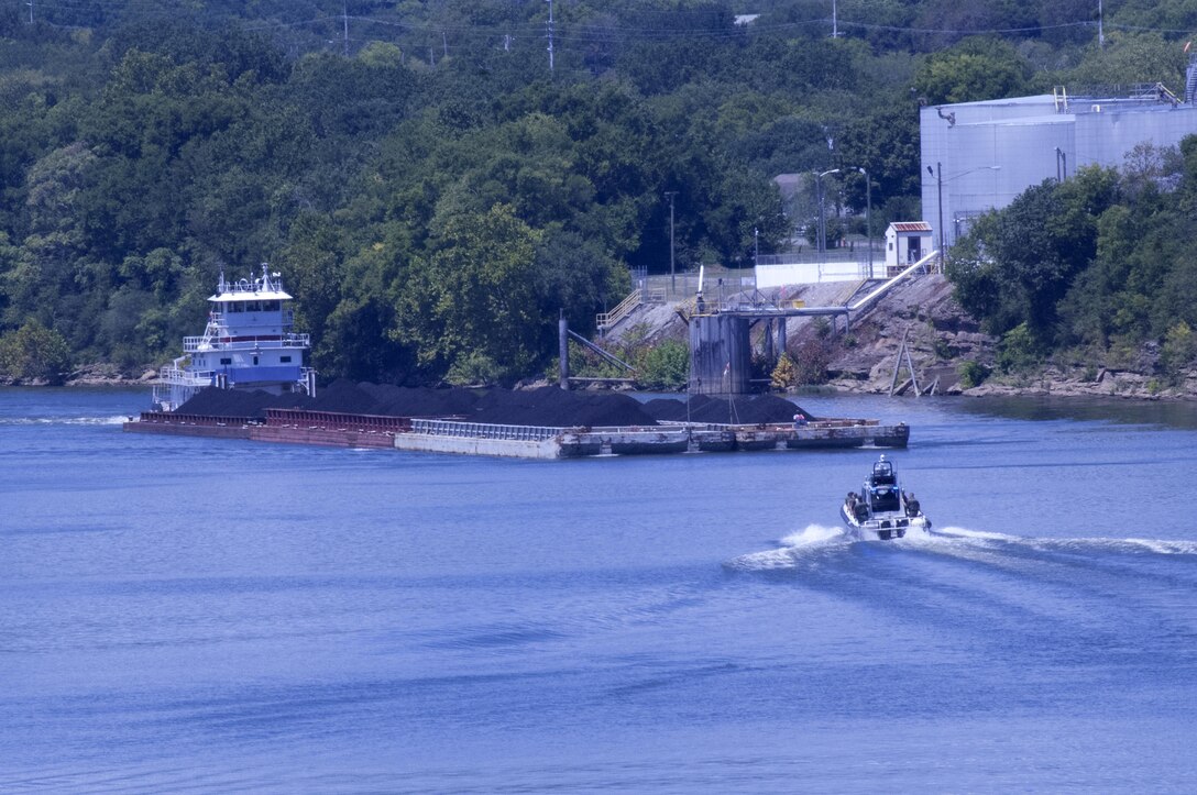 A Nashville Metro Police vessel approaches a barge tow full of coal headed for the Gallatin Steam Plant on the Cumberland River in Nashville, Tenn., Aug. 12, 2015.  The photo was taken from the Motor Vessel Mississippi as it approached from the opposite direction with a group of stakeholders headed to Cheatham Lock and Dam in Ashland City, Tenn.  The stakeholders were onboard to interact with the Mississippi River Commission in the process of conducting a low water inspection of the Cumberland River. 
