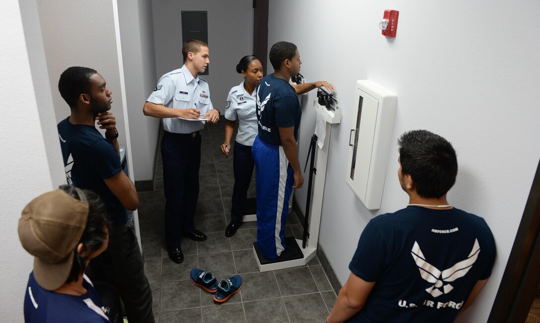 Tech. Sgt. Tanisha Ross, Enlisted Accessions Recruiter, 341st Recruiting Squadron, and Senior Airman Jacob Histo, Recruiting Assistance Program member, weigh Delayed Entry Program members in Live Oak, Texas, July 6, 2015. Ross weighs DEP members to ensure they are meeting standards to be able to attend Basic Military Training.  (U.S. Air Force photo by Tech. Sgt. Joshua Strang)