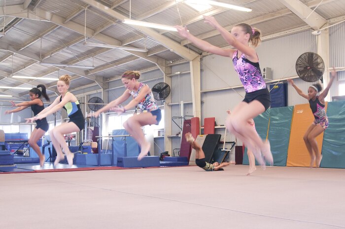 (Left to right): Ariel Hernandez, 11, Cascade Johnson, 13, Grace Ritz, 12, and Malia Alana, 11, work on tuck jumps during their K-Bay Gymnastics practice, Aug. 10, 2015. They are training to compete with the Rainbow Gymnastics Academy at the Kick-Off Meet, Aug. 31. K-Bay Gymnastics is part of Marine Corps Community Services, an organization which aims to contribute to the readiness and retention of Marines, Sailors and family members aboard Marine Corps Base Hawaii by providing fitness and recreation programs, Marine and family programs and business activities in garrison and deployed environments. (U.S. Marine Corps photo by Maria Kanai/Released)