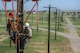 U.S. Air Force Staff Sgt. Andrew Goodrick, (left), from Nellis Air Force Base, Nevada, and Airman 1st Class Jaylen Wilkens, from Charleston Air Force Base, South Carolina, train as 366th Training Squadron Hotline Training Course students at Sheppard Air Force Base, Texas, Aug. 7, 2015. Goodrick and Wilkens secured a tool called “the tree” that safely lifts power lines from the insulators. They use this tool to transfer the power lines to a new pole. Airmen in this course wear a modified uniform to protect themselves from the various equipment and chemicals they use. (U.S. Air Force photo by Senior Airman Kyle Gese)