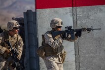 Marines with Company A, 1st Battalion, 7th Marine Regiment, move at the alert in between buildings during a Military Operation on Urban Terrain exercise aboard Marine Corps Air Ground Combat Center Twentynine Palms, California, Aug. 11, 2015. The MOUT exercise was part of an Integrated Training Exercise that allowed the Marines with Animal Company to showcase their different capabilities in preparation for future deployments.