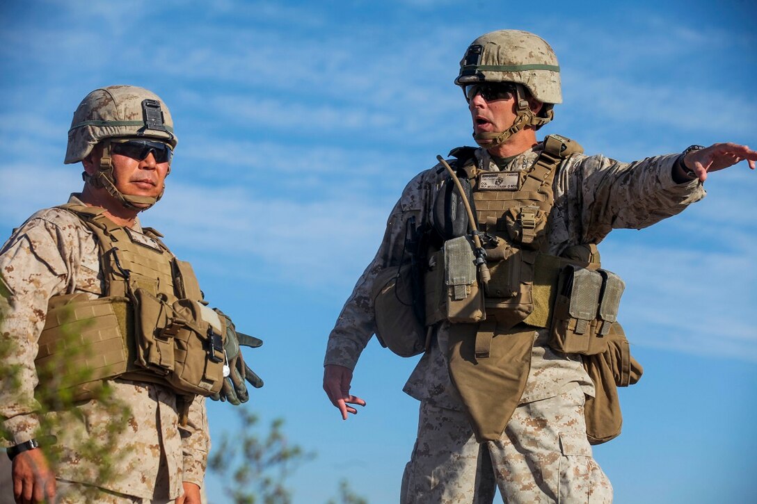 Colonel William Mccollough, the commanding officer of 1st Marine Regiment, 1st Marine Division, explains military operations on urban terrain procedures to Brig. Gen. Daniel Yoo, the deputy commanding general of 1st Marine Division, at a live-fire MOUT exercise conducted by Company A, 1st Battalion, 7th Marine Regiment, aboard Marine Corps Air Ground Combat Center Twentynine Palms, California, Aug. 11, 2015. The MOUT exercise was conducted as part of Integrated Training Exercise and allowed the Marines to practice many different capabilities in preparation for future deployments.