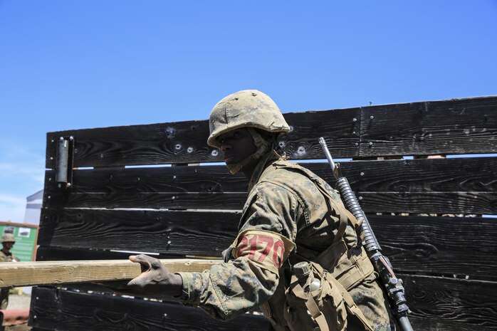 Recruit Abdi A. Mohamed, Hotel Company, 2nd Recruit Training Battalion, lifts a board to another recruit during the Leadership Reaction Course at Marine Corps Base Camp Pendleton, Aug. 5. Following recruit training, he will move on to the School of Infantry for Marine Combat Training at Marine Corps Base Camp Pendleton, Calif., and from there will go to his Military Occupational Specialty as a motor transportation specialist. He plans on getting as much as he can out of the Corps and give his service as a repayment for everything he has been given.  Today, all males recruited from west of the Mississippi are trained at MCRD San Diego. The depot is responsible for training more than 16,000 recruits annually. Hotel Company is scheduled to graduate Aug. 14.