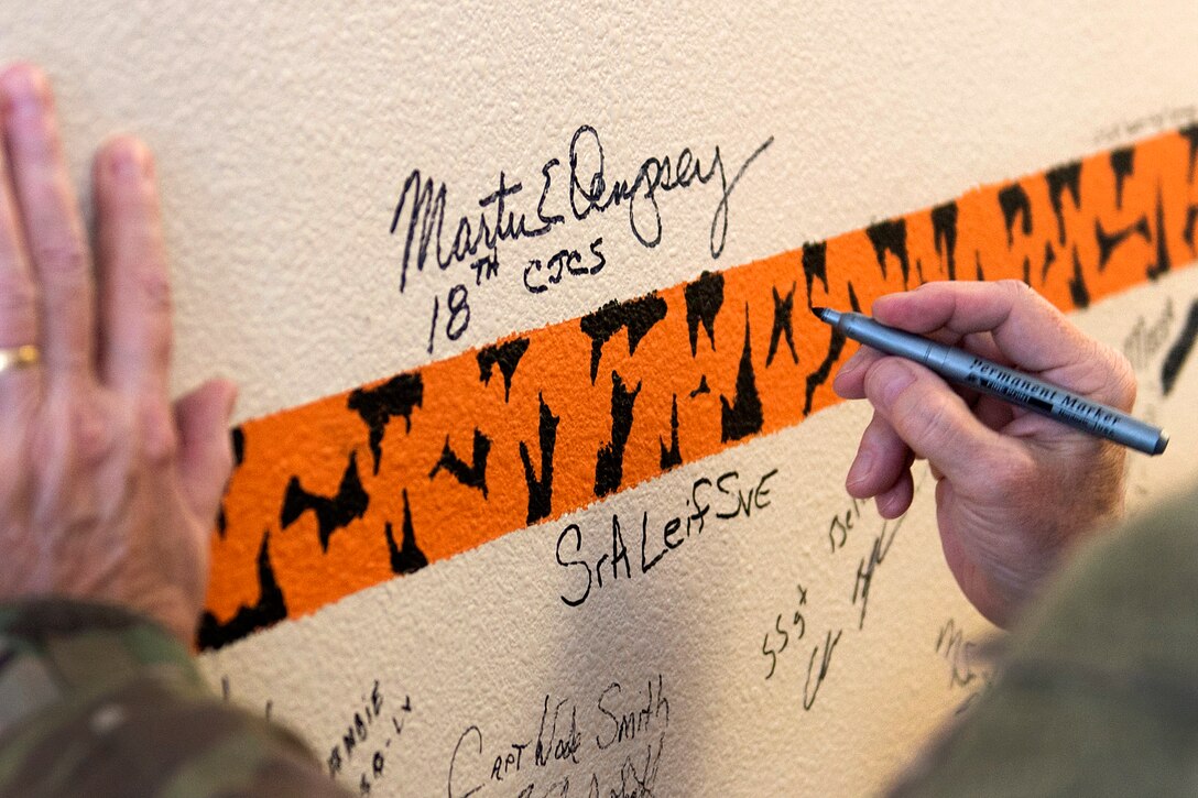 Army Gen. Martin E. Dempsey, chairman of the Joint Chiefs of Staff, signs the wall in the recreation room of a remotely piloted aircraft squadron at Creech Air Force Base, Nev., Aug. 12, 2015.