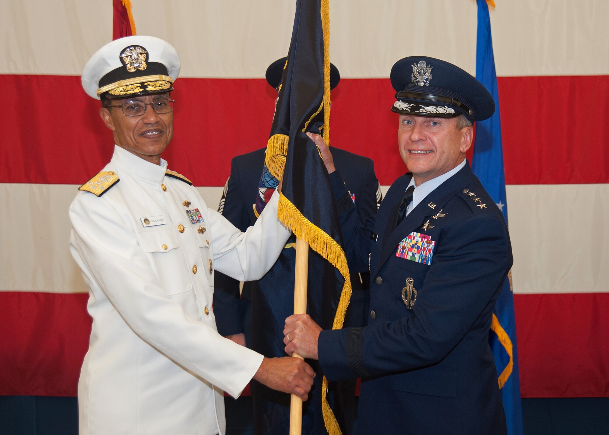 U.S. Navy Adm. Cecil D. Haney, commander, U.S. Strategic Command, passes the Joint Functional Component Command for Space guidon to the new commander, U.S. Air Force Lt. Gen. David J. Buck, during a change of command ceremony Aug. 14, 2015, at Vandenberg Air Force Base, Calif. Established in July 2006, JFCC Space is a component of USSTRATCOM and is responsible for executing continuous, integrated space operations to deliver theater and global effects in support of national and combatant commander objectives. (U.S. Air Force photo/Michael Peterson)