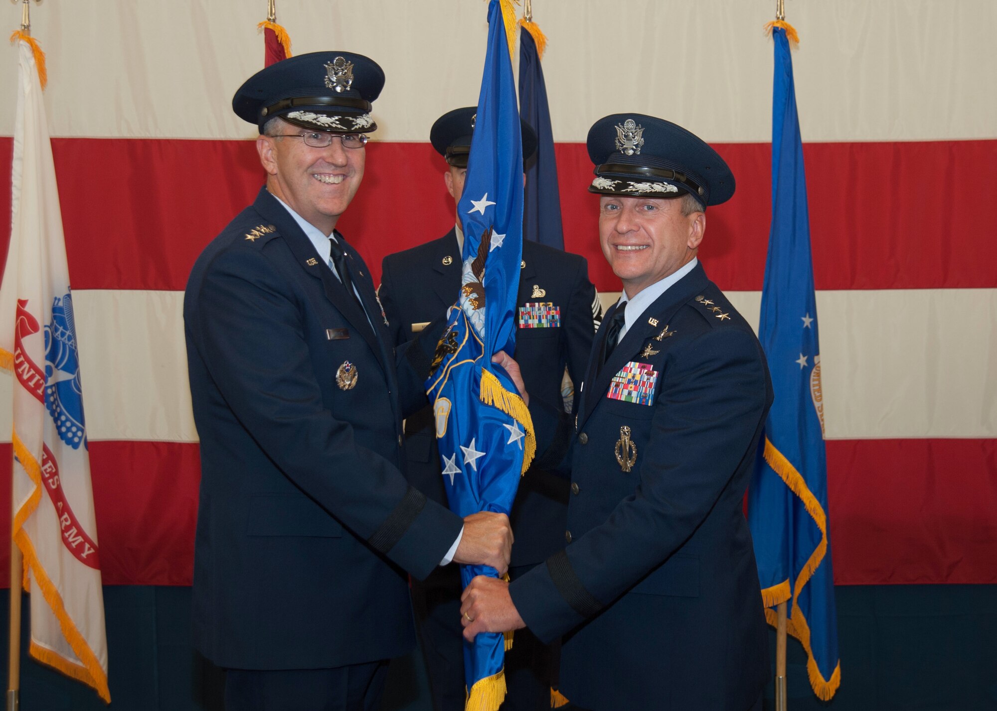 U.S. Air Force Gen. John E. Hyten, commander of Air Force Space Command, passes the 14th Air Force guidon to the new commander, U.S. Air Force Lt. Gen. David J. Buck, during a change of command ceremony Aug. 14, 2015, at Vandenberg Air Force Base, Calif. As the Air Force's sole numbered Air Force for space, 14th AF is responsible for the organization, training, equipping, command and control and employment of Air Force space forces to support operational plans and missions for U.S. combatant commanders and air component commanders. (U.S. Air Force photo/Michael Peterson)