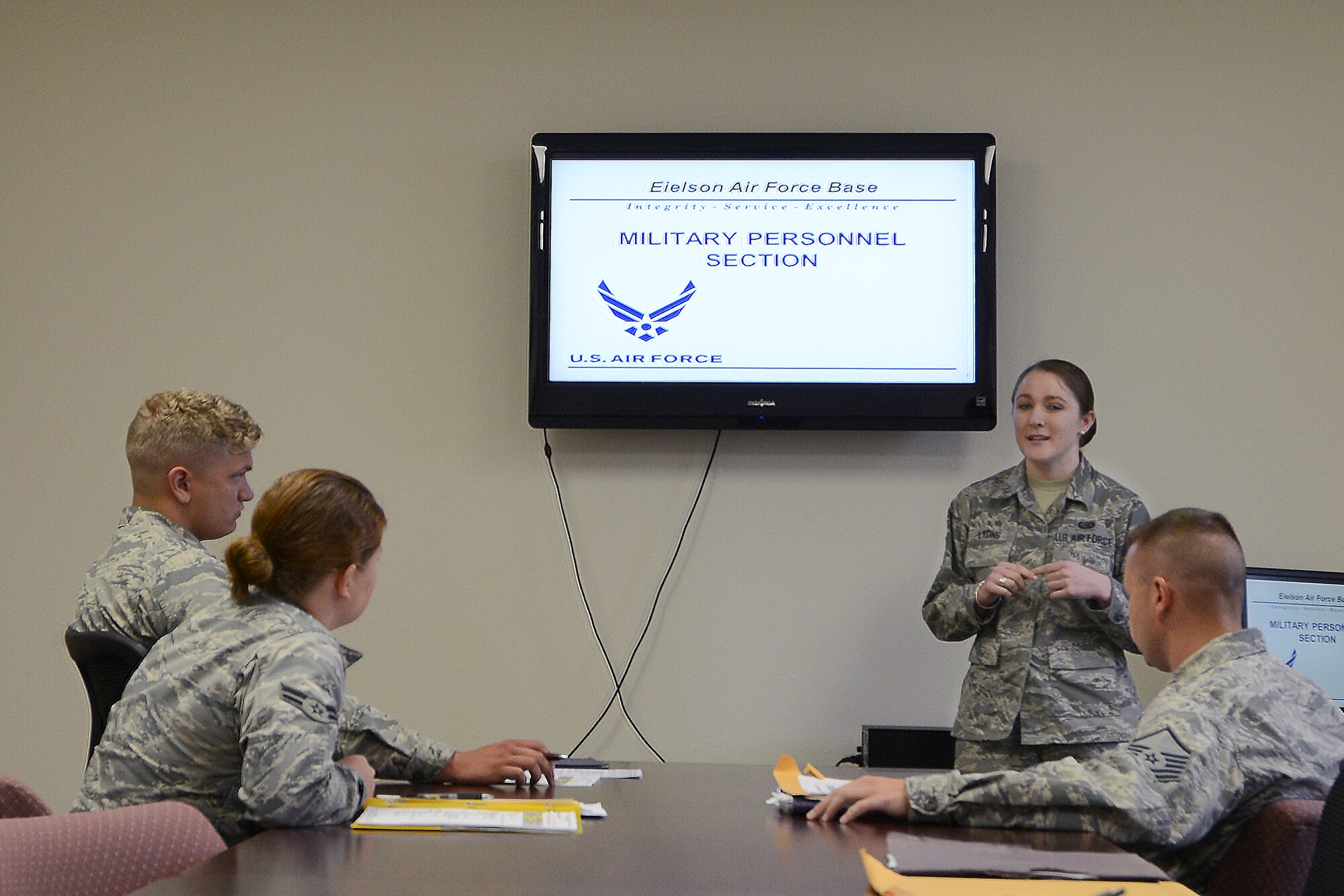 U.S. Air Force Senior Airman Alicia Lyons, a 354th Force Support Squadron career development journeyman, gives Airmen a welcome briefing, Aug. 12, 2015, at Eielson Air Force Base, Alaska. The personnel section will in-process Airmen every Monday, Wednesday and Friday. (U.S. Air Force photo by Senior Airman Ashley Nicole Taylor/Released) 
