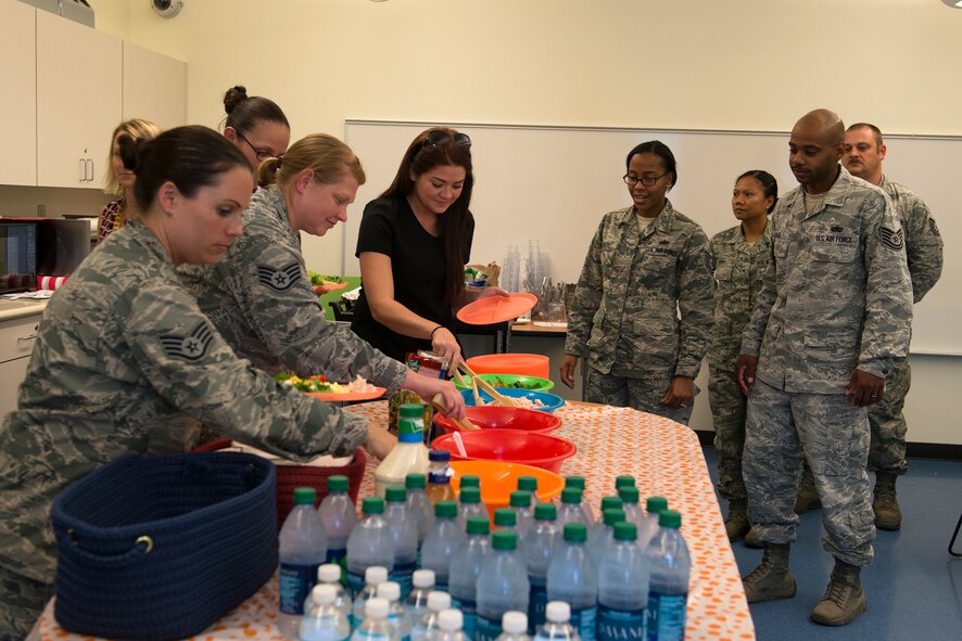Parents of children from Moody’s Youth Programs prepare salads for a family meal during Kids Eat Right Month, Aug. 13, 2015, at Moody Air Force Base, Ga. Kids Eat Right month highlights the significance of eating healthy and staying active for children and families. (U.S. Air Force photo by Airman 1st Class Kathleen D. Bryant/Released)