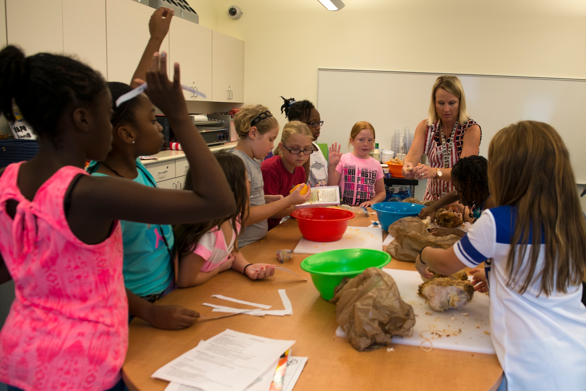 Erin Locke, 23d Medical Group health promotion dietician, helps Moody’s Youth Programs’ children prepare food for a family meal during Kids Eat Right Month, Aug. 13, 2015, at Moody Air Force Base, Ga. To celebrate healthy eating, the children attended a nutrition class taught by Locke, planned a meal, prepped and served their parents. (U.S. Air Force photo by Airman 1st Class Kathleen D. Bryant/Released)