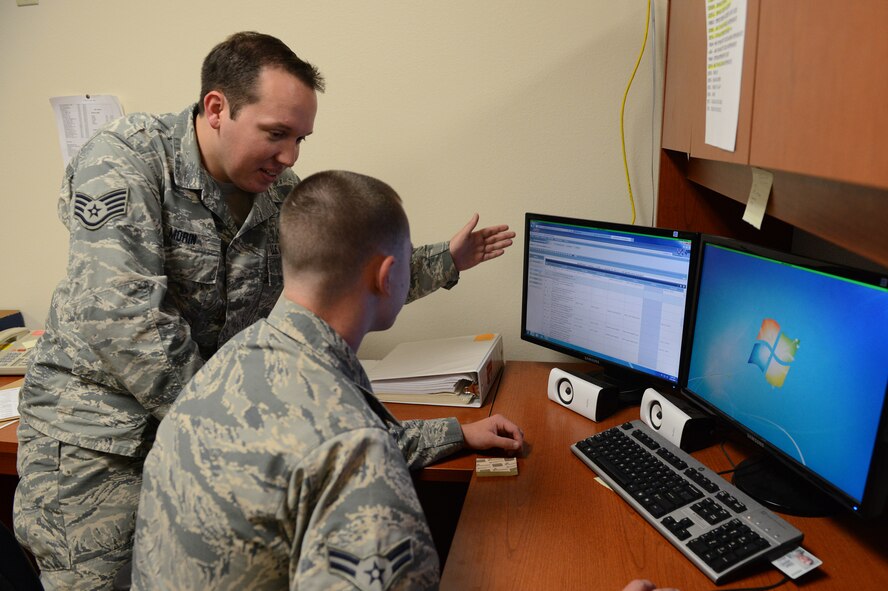 Staff Sgt. John Morin, 56 Comptroller Squadron customer service technician, shows Airman 1st Class Kevin Dawson, 56th CPTS customer service technician, where he stands in tasks completed on Air Force Training Records on the Air Force portal at Luke Air Force Base, Arizona, Aug. 11, 2015. Morin was giving Dawson advice on what tasks to complete in order for him to move forward in his tasks quickly. (U.S. Air Force photo by Senior Airman James Hensley) 