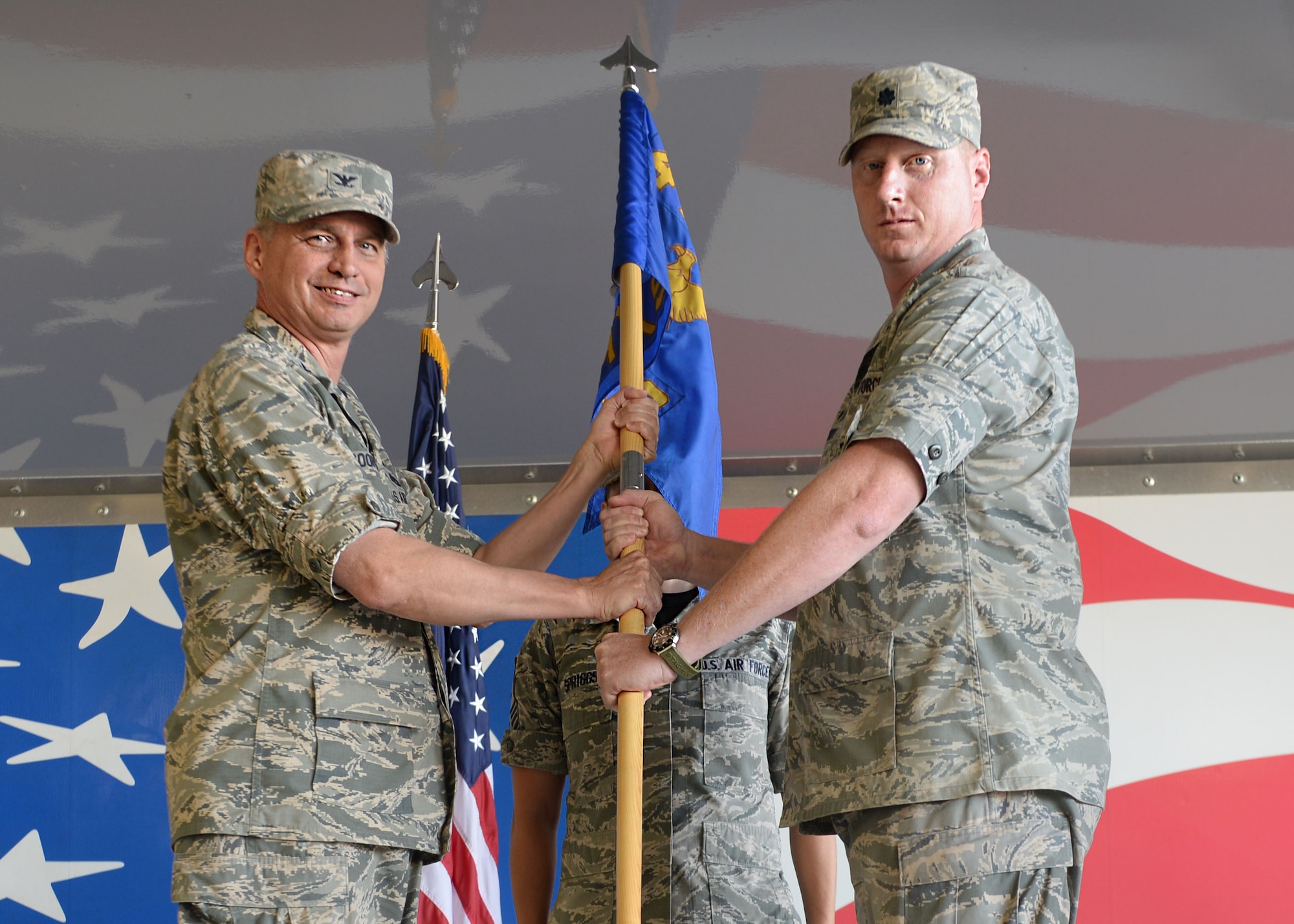 (Right) Lt. Col. Jason Purdy, outgoing 4th Aircraft Maintenance Squadron commander, passes the guidon to Col. Shannon Cooper, 4th Maintenance Group commander during the squadron’s change of command, Aug. 14, 2015, at Seymour Johnson Air Force Base, North Carolina. During his two years at Seymour Johnson AFB, Purdy was responsible for thousands of Airmen who perform flightline maintenance on the 4th Fighter Wing’s F-15E Strike Eagles. (U.S. Air Force photo/Airman 1st Class Ashley Williamson)