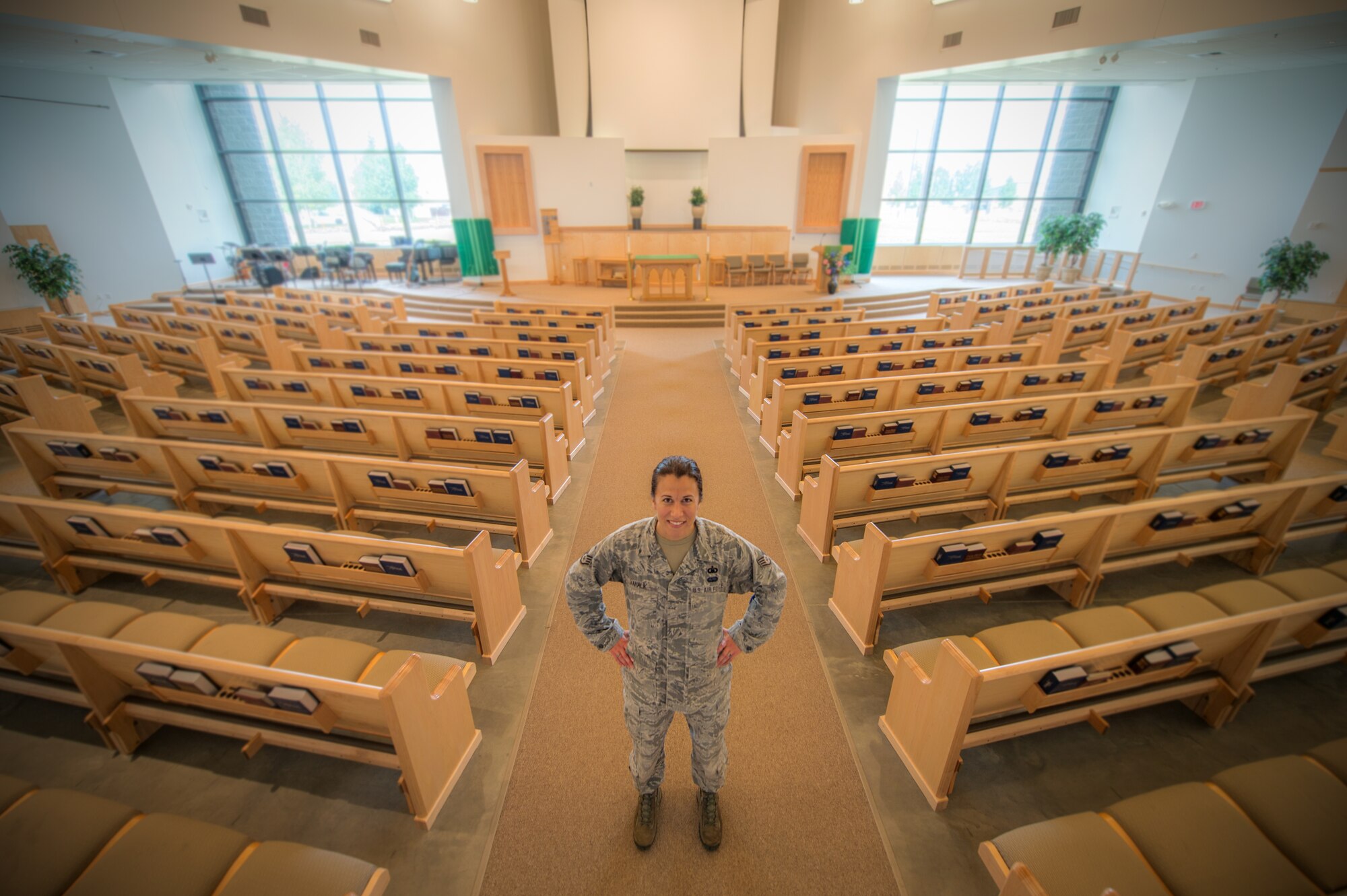 U.S. Air Force Staff Sgt. Jen Vahalik, the 354th Fighter Wing NCO in-charge of chapel plans and programs, stops work for a brief photo July 29, 2015, in the Base Chapel at Eielson Air Force Base, Alaska. Vahalik said the favorite part of her job is being able to help and encourage Airmen and their families. (U.S. Air Force photo by Staff Sgt. Shawn Nickel/Released) 
