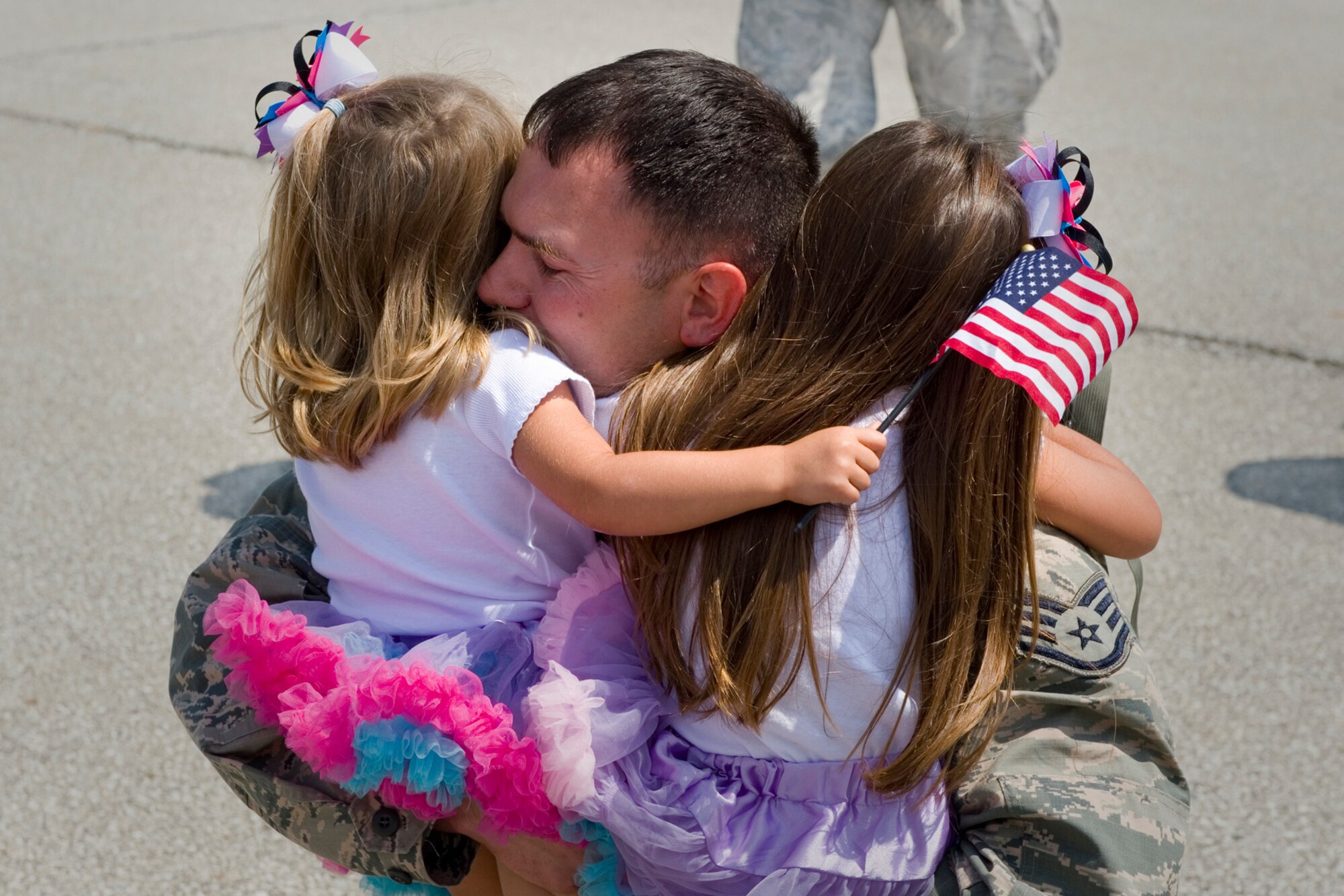 Staff Sgt. Cory Tuell, 434th Security Forces Squadron fire team member, embraces his daughters Kinslee, left, and Paislee at Grissom Air Reserve Base, Ind., August 8, 2015. Paislee was one of 14 Airmen returning home after a 180-day deployment to Southwest Asia. (U.S. Air Force photo/Tech. Sgt. Benjamin Mota)