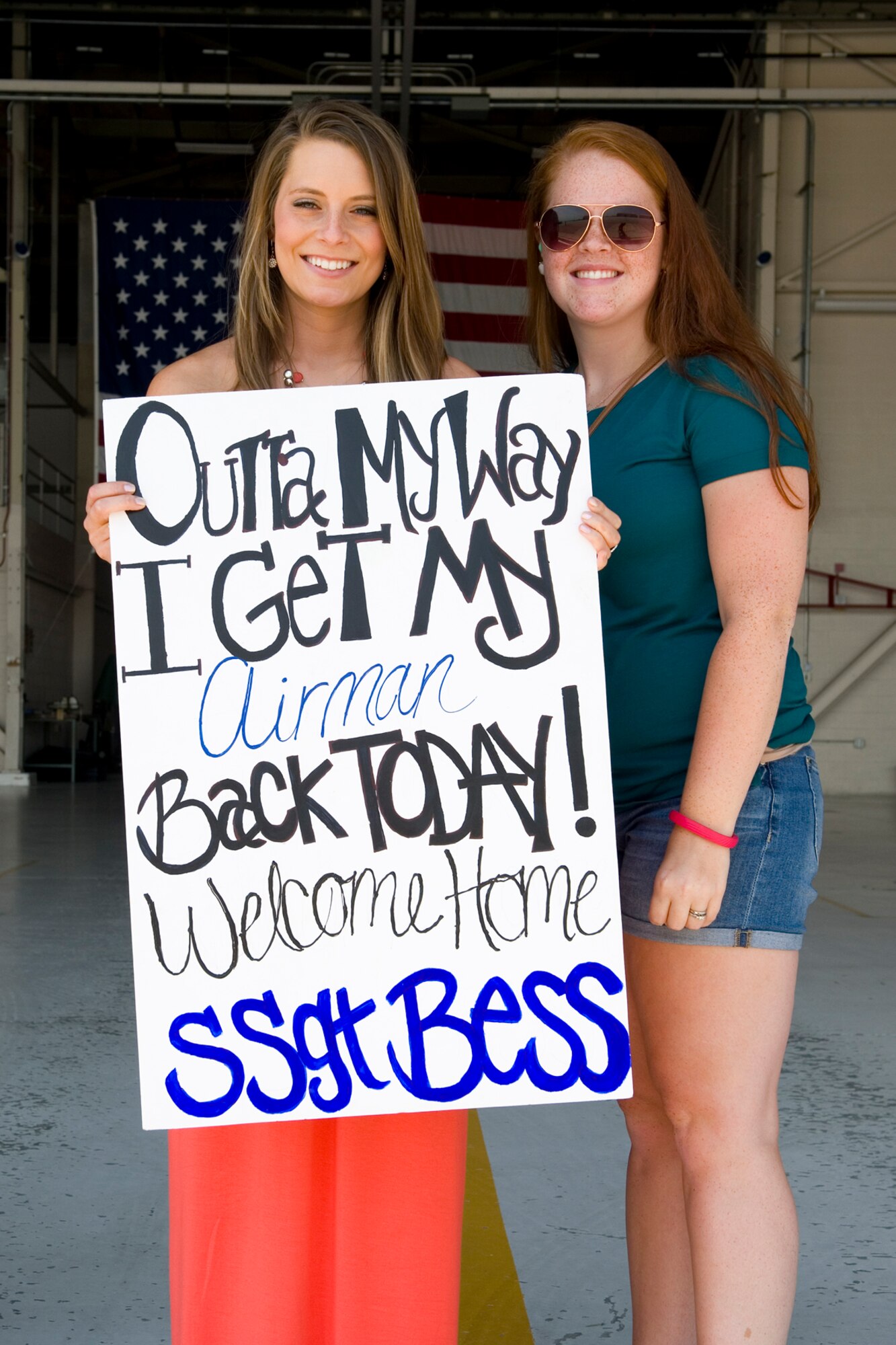 Morgan Forebush, girlfriend of Senior Airman Jade Bess, 434th Security Forces Squadron fire team member, and Katee Abney, hold a sign to greet returning Airmen at Grissom Air Reserve Base, Ind., August 8, 2015. Families and friends gathered to welcome 14 defenders home from a 180-day deployment to Southwest Asia. (U.S. Air Force photo/Tech. Sgt. Benjamin Mota) 