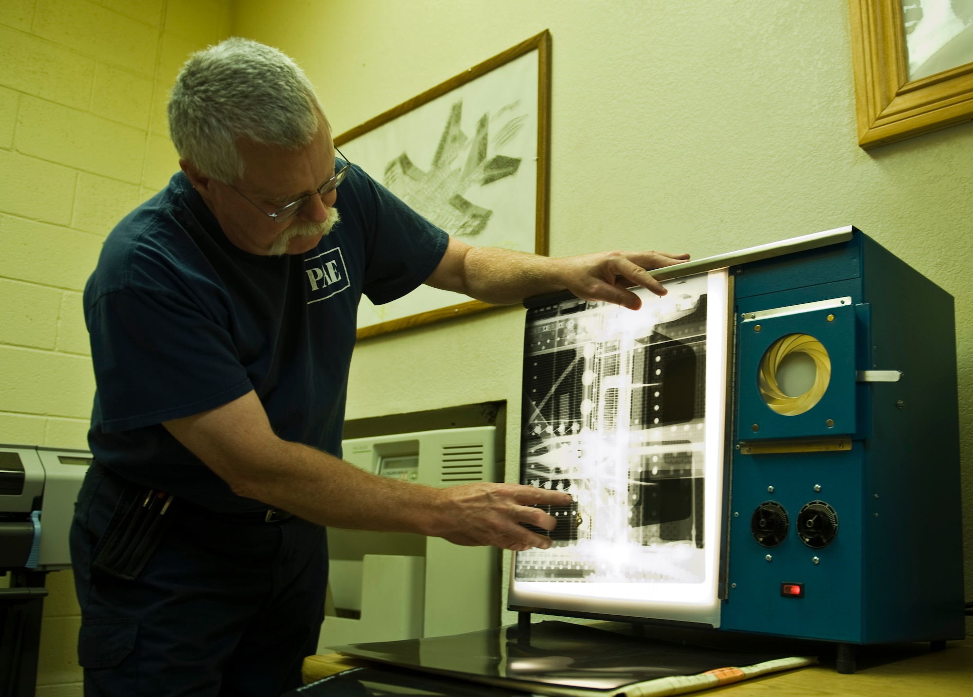John Sanders, a contractor with the 57th Maintanence Group, looks at a film x-ray of an aircraft at the Nondestructive Inspection Laboratory on Nellis Air Force Base, Nev., Aug. 11, 2015. The NDI Lab utilizes x-rays to pin-point possible damage to aircraft components.(U.S. Air Force photo by Airman 1st Class Rachel Loftis)