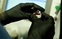 Stephanie Zvonik, a contractor with the 57th Maintanence Group, pours oils into a cap for testing at the Nondestructive Inspection Laboratory on Nellis Air Force Base, Nev., Aug. 11. The NDI Lab test all Nellis AFB aircraft oil to ensure the integrity of the aircraft. (U.S. Air Force photo by Airman 1st Class Rachel Loftis)